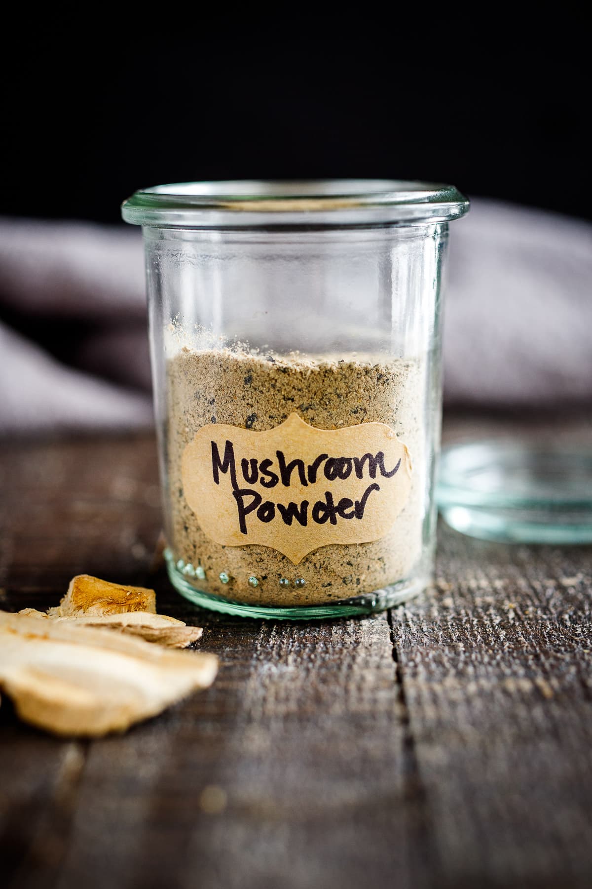 mushroom powder in a small spice jar with a label on the counter.