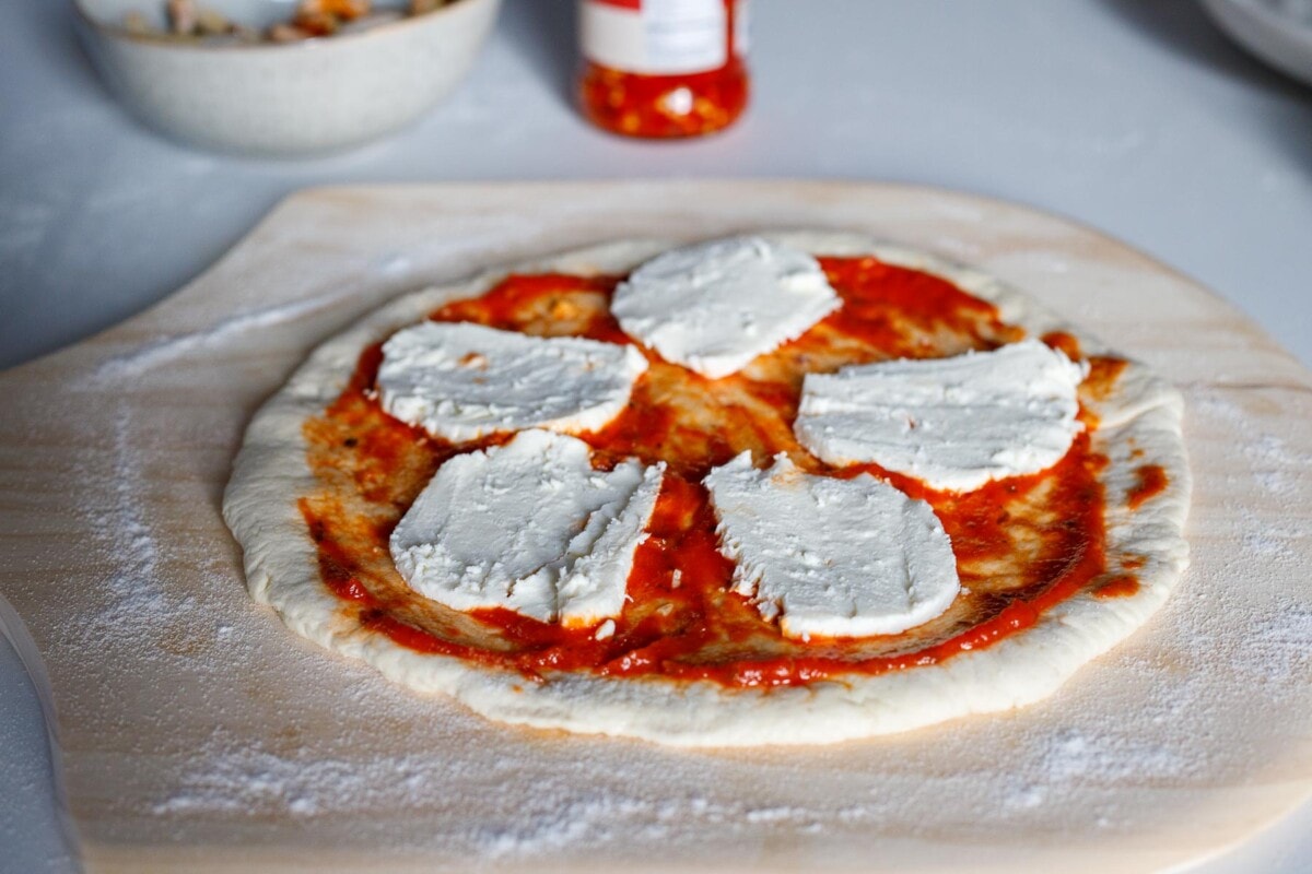 Pizza dough with tomato sauce and mozzarella.
