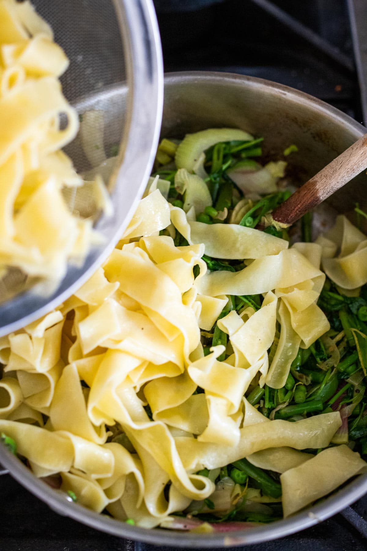 Tossing the pasta with the veggies. 