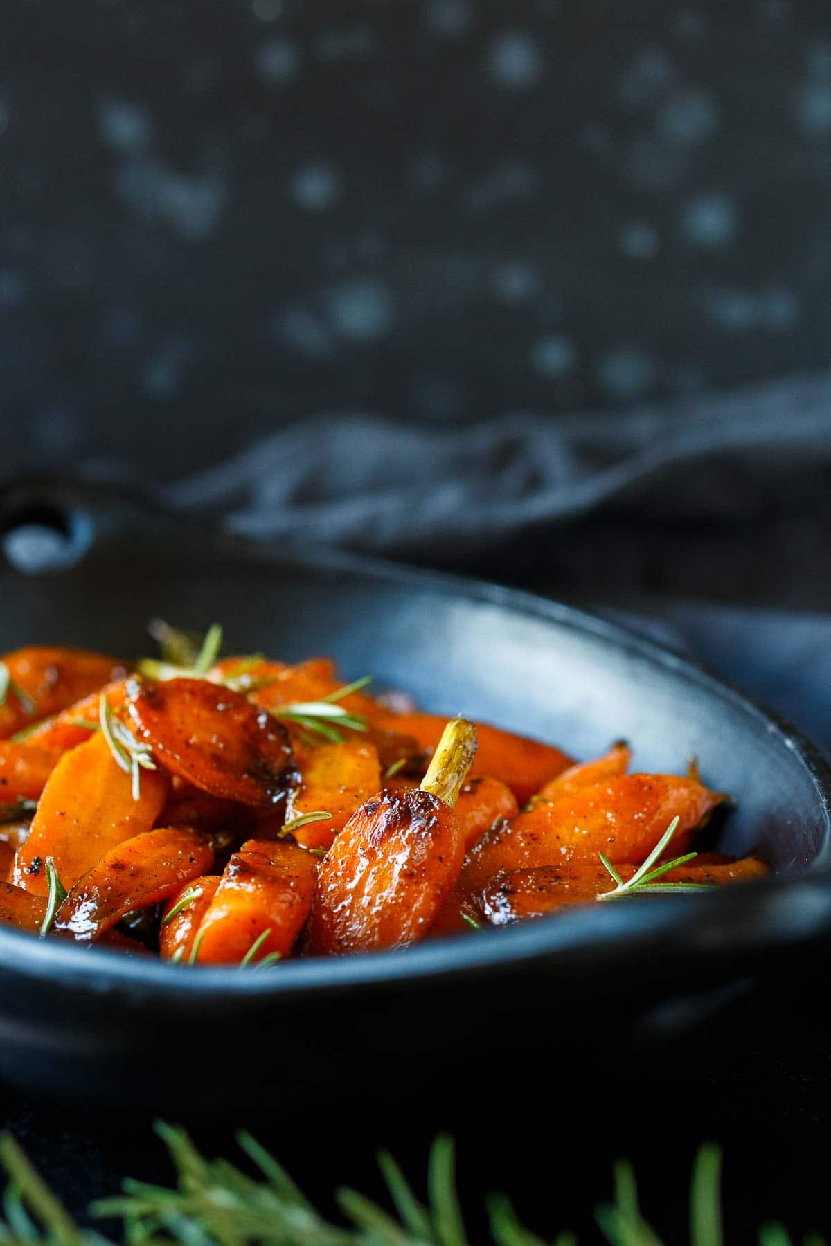 glazed carrtos in a black oval serving dish