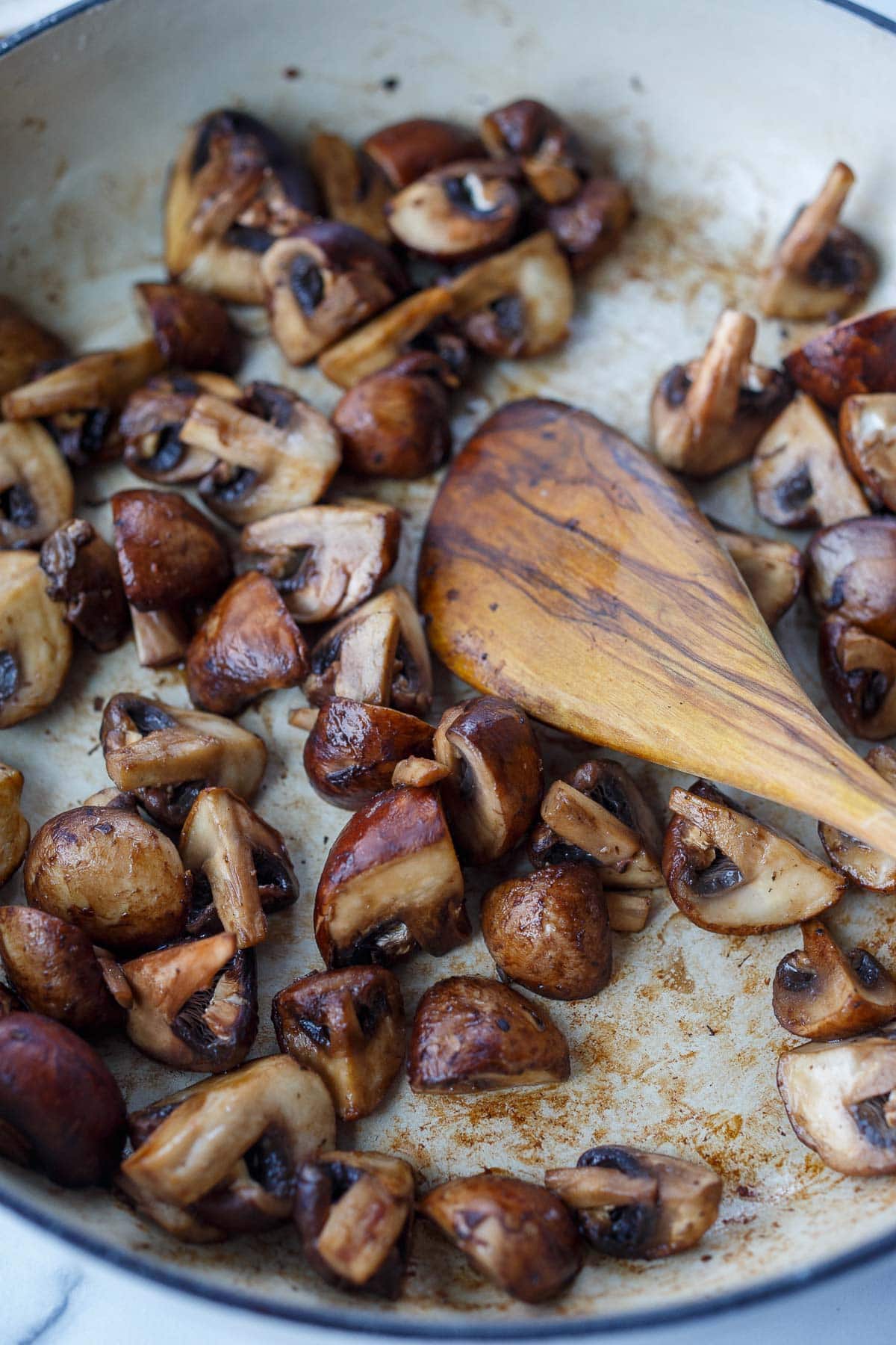 chopped mushrooms sautéing in pan.