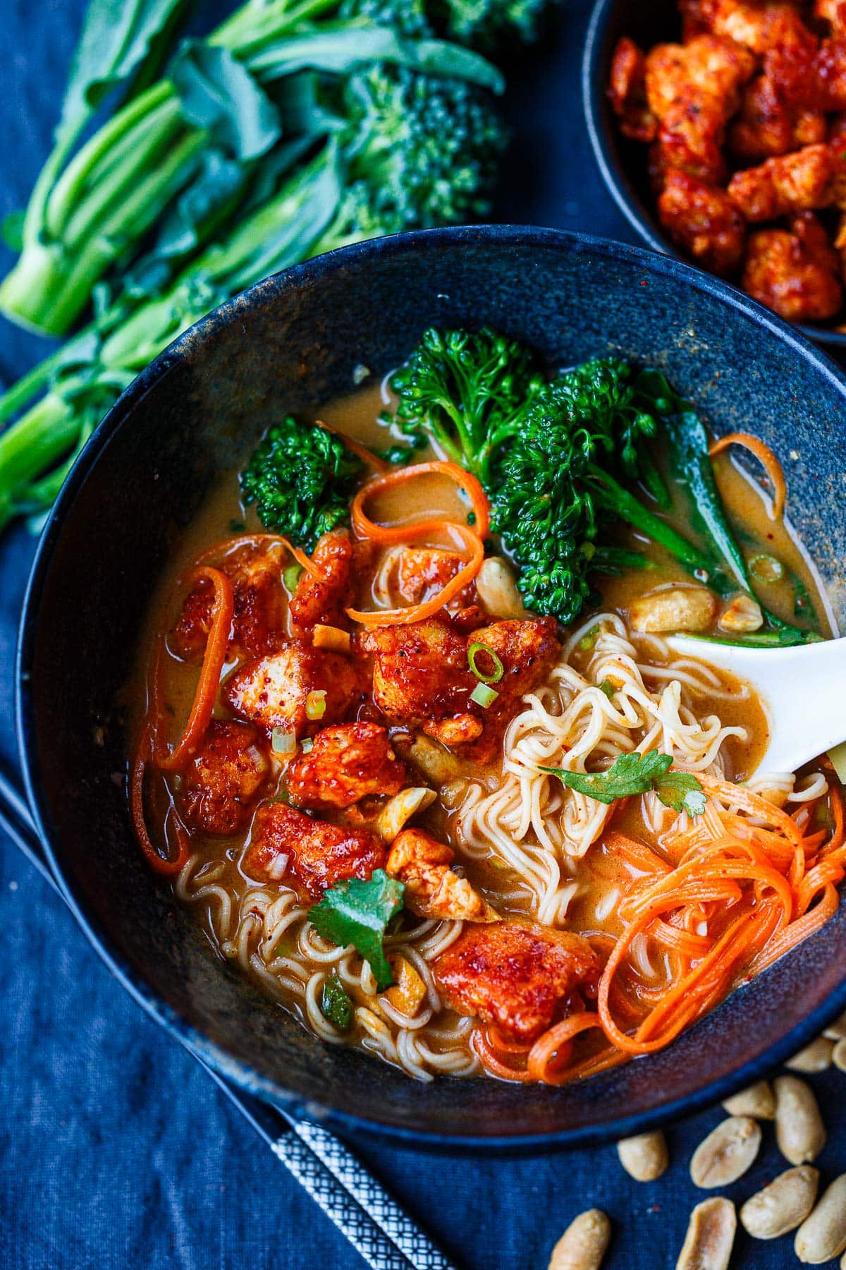 bowl of peanut butter ramen with broccolini, shredded carrots, and crispy Korean tofu.