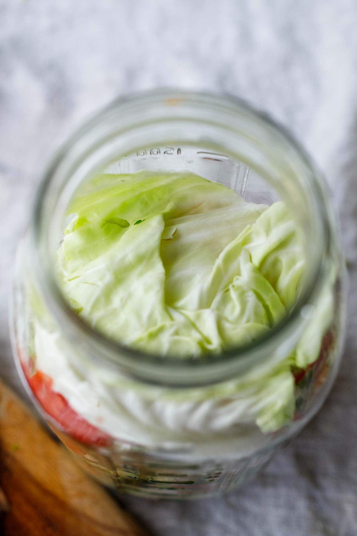 using a cabbage leaf to keep veggies down in the jar.