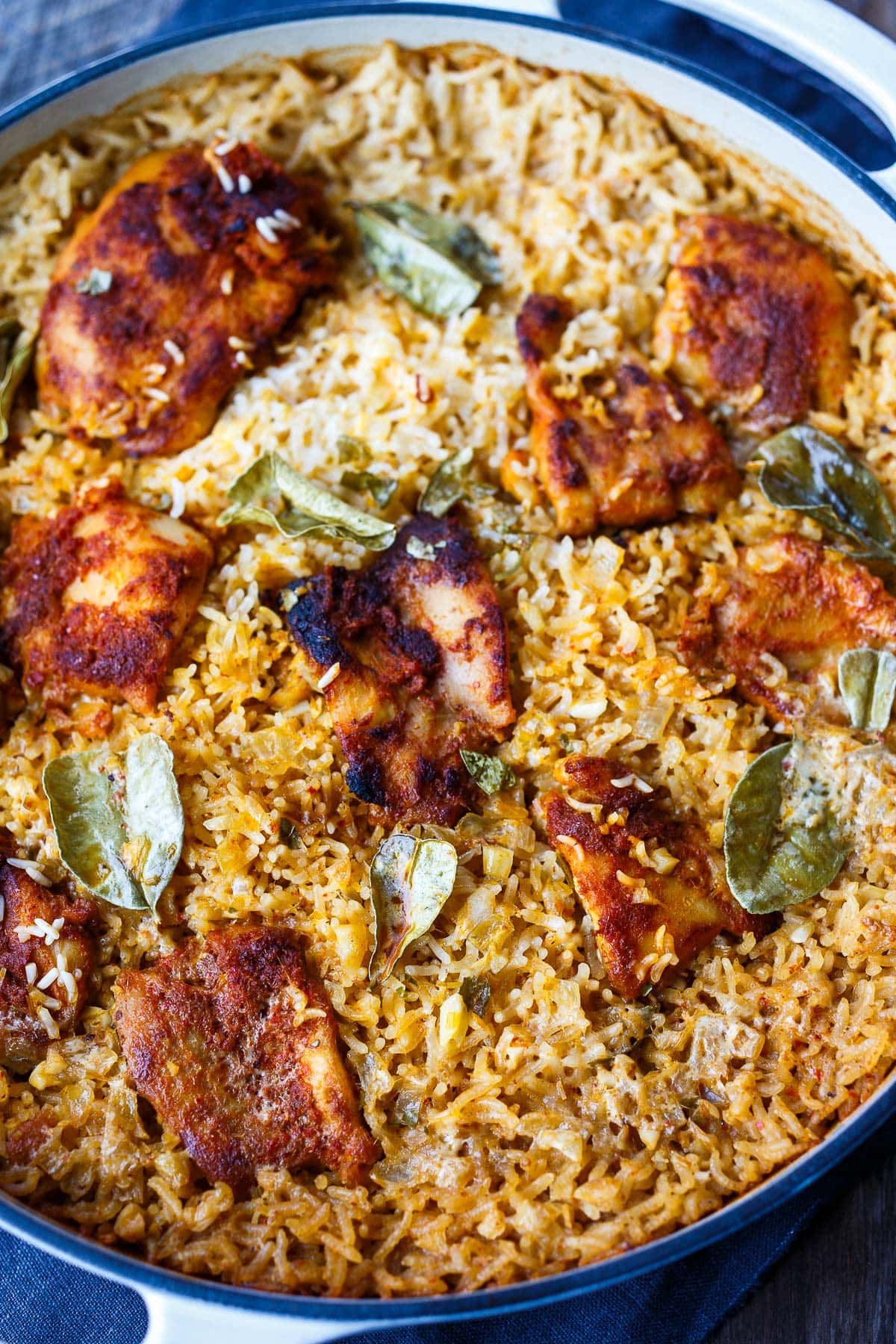 baked red curry chicken nestled in cooked rice in dutch oven.