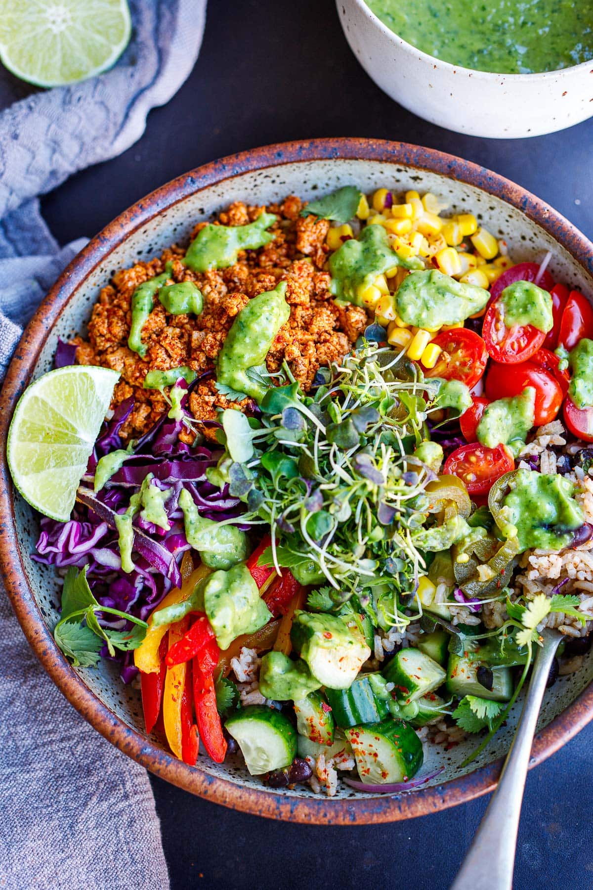 A burrito bowl with sofritas, rice, black beans, fresh veggies, lime, and avocado sauce.