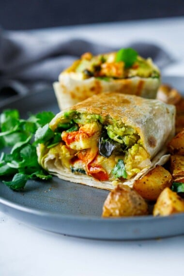 Toasted breakfast burrito on a plate.