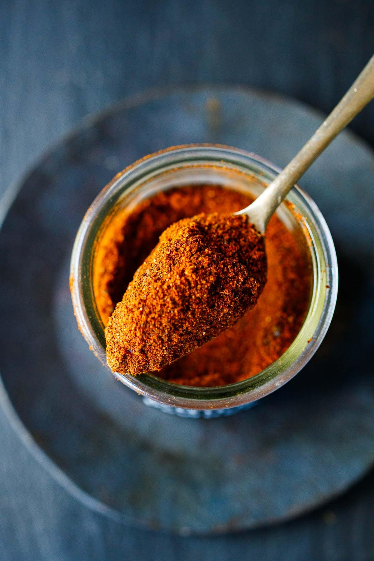 homemade Chile Powder in a jar with a spoon.