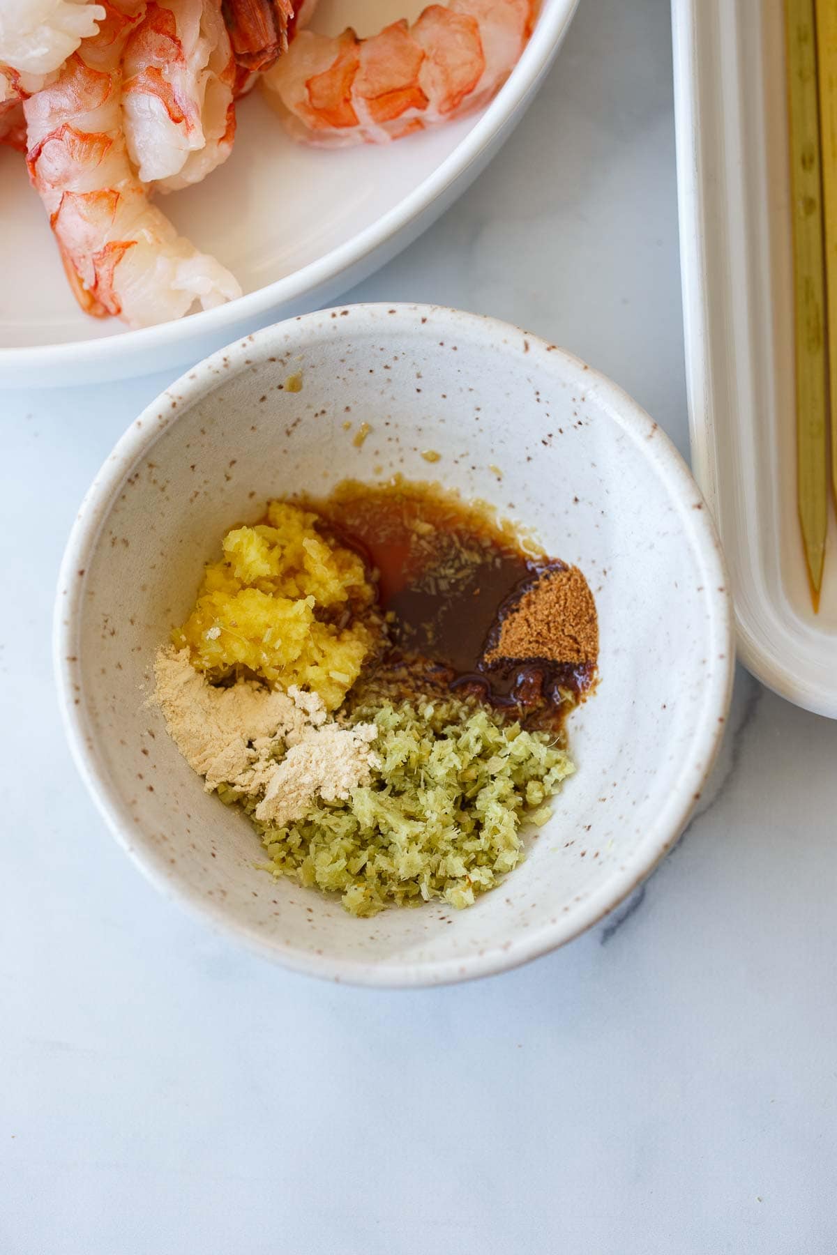 lemongrass marinade in small bowl next to raw shrimp. 