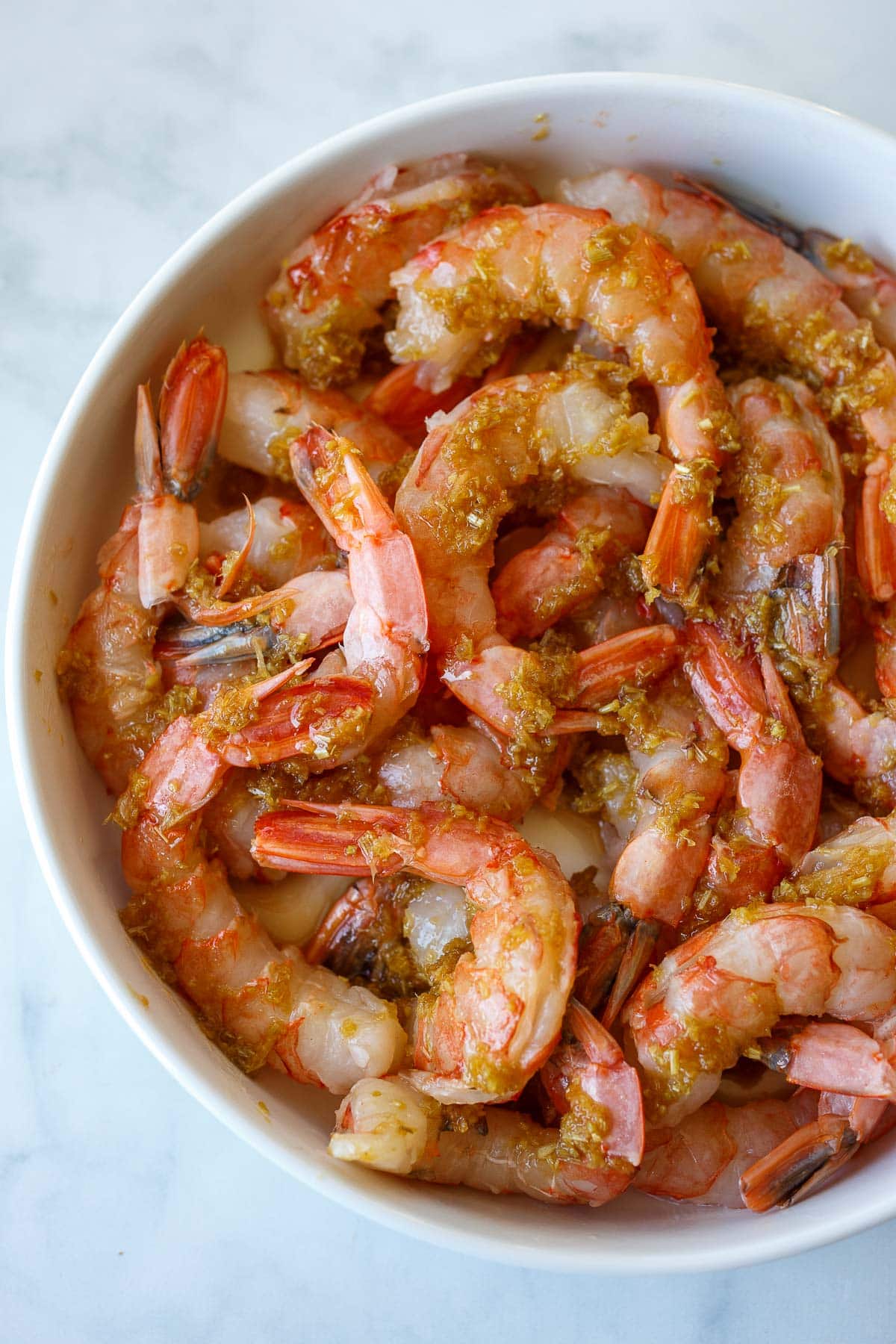 raw shrimp marinating in lemongrass marinade in bowl. 