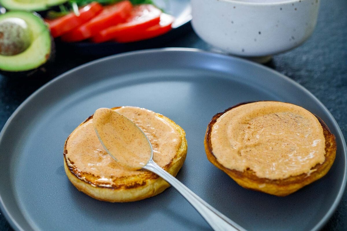 two toasted brioche buns with chipotle mayo spread over top.