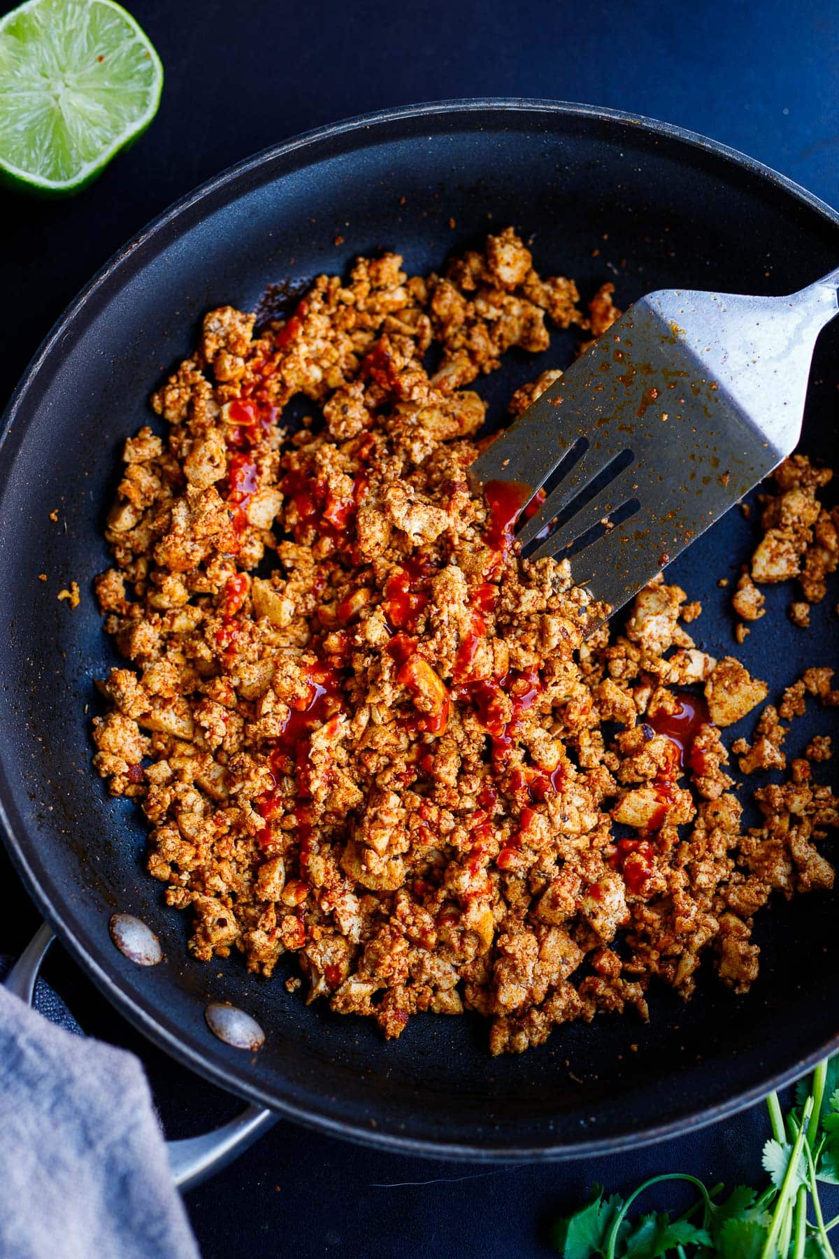 frying sofritas in skillet, topped with hot sauce.