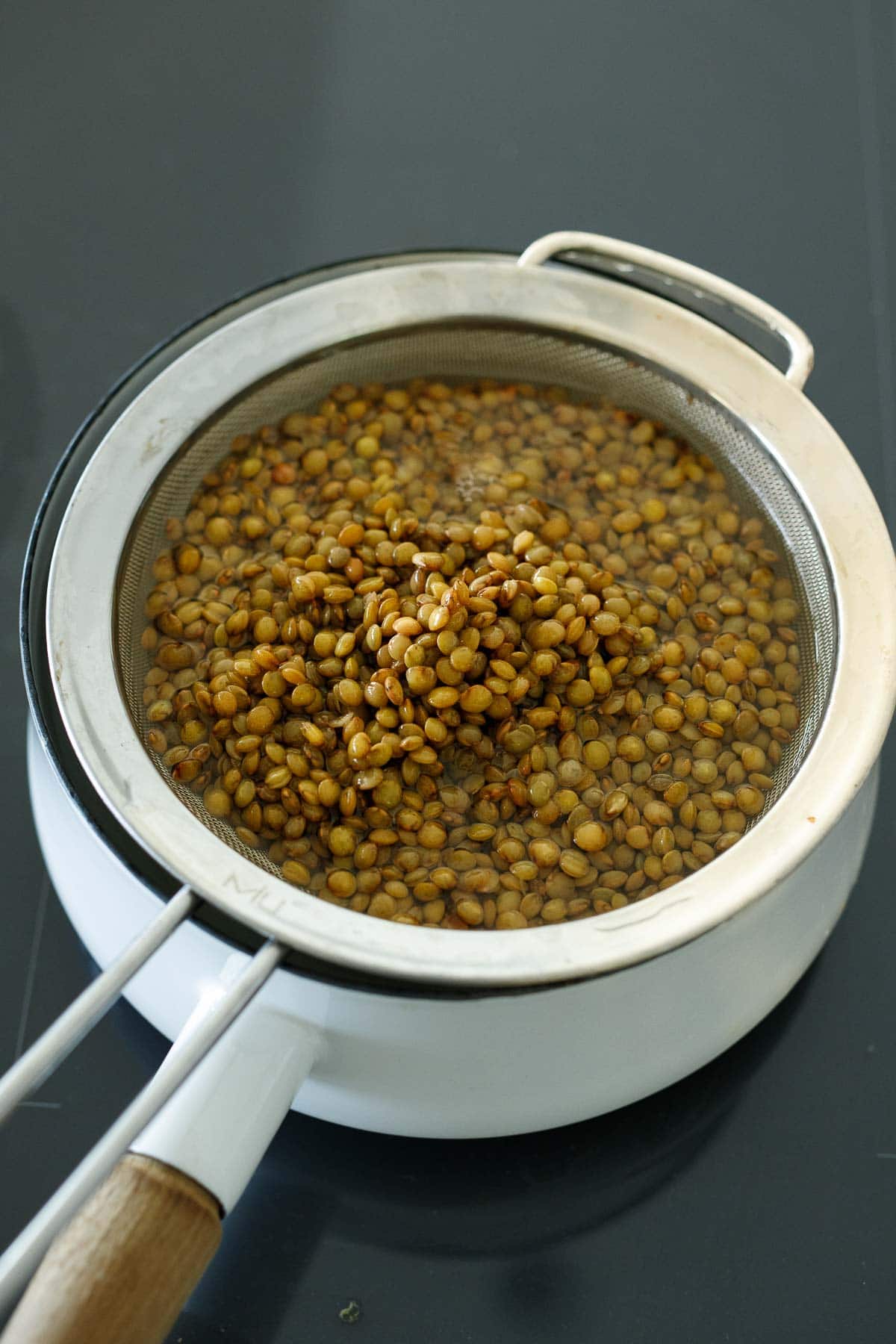 lentils in colander over pot.