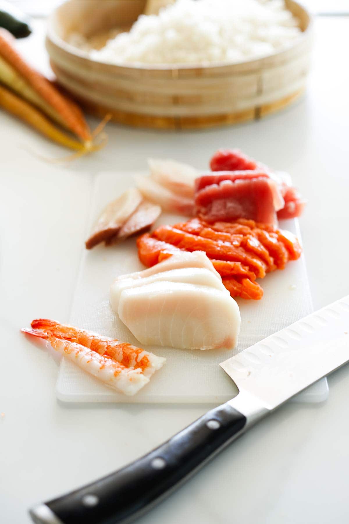cutting board with sliced fish and sharp knife.