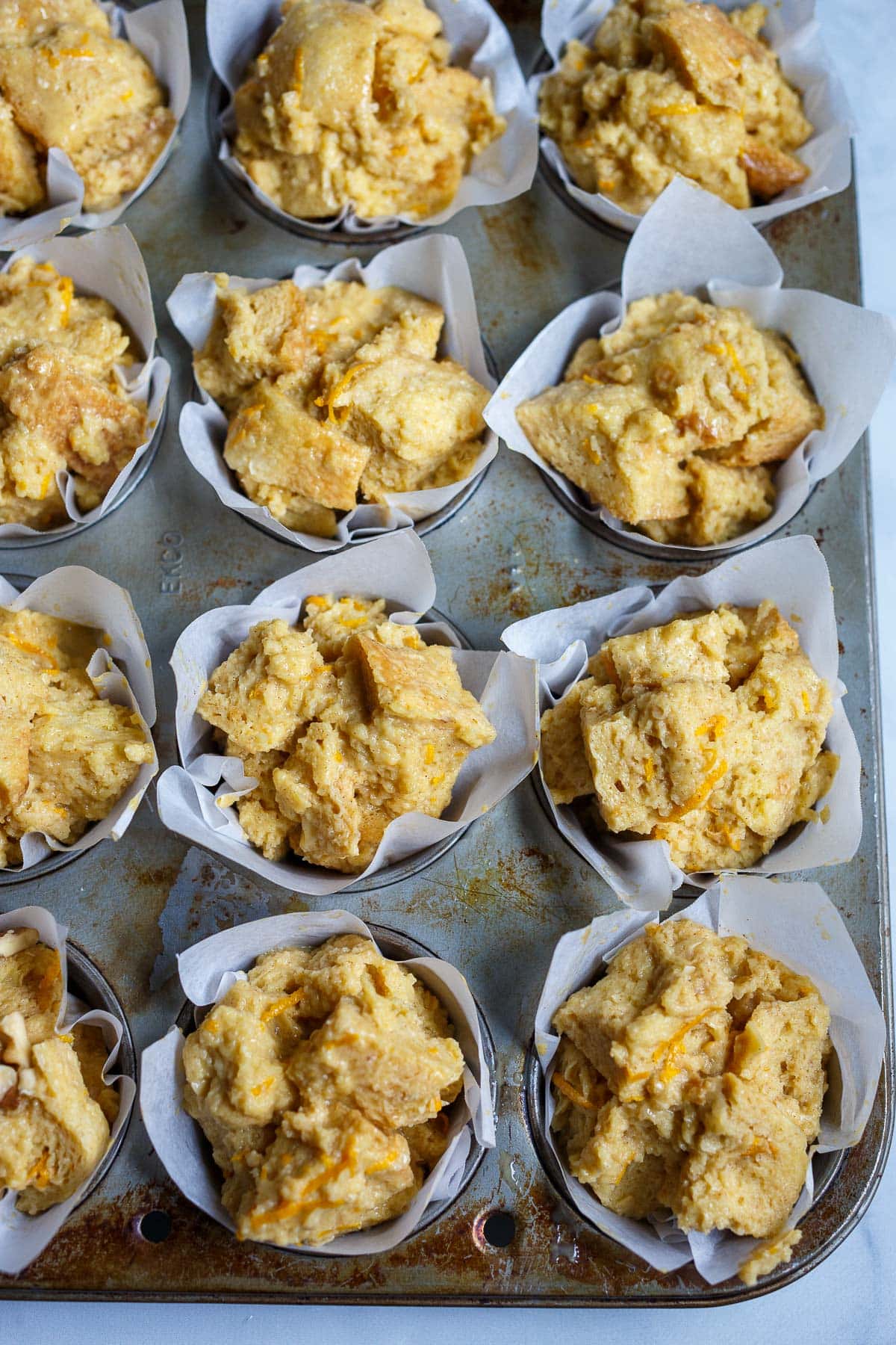 muffin pan with French toast muffin batter in paper liners.