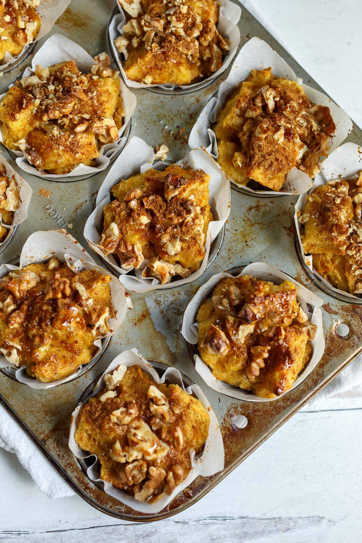 baked French toast muffins in muffin pan with paper liners.