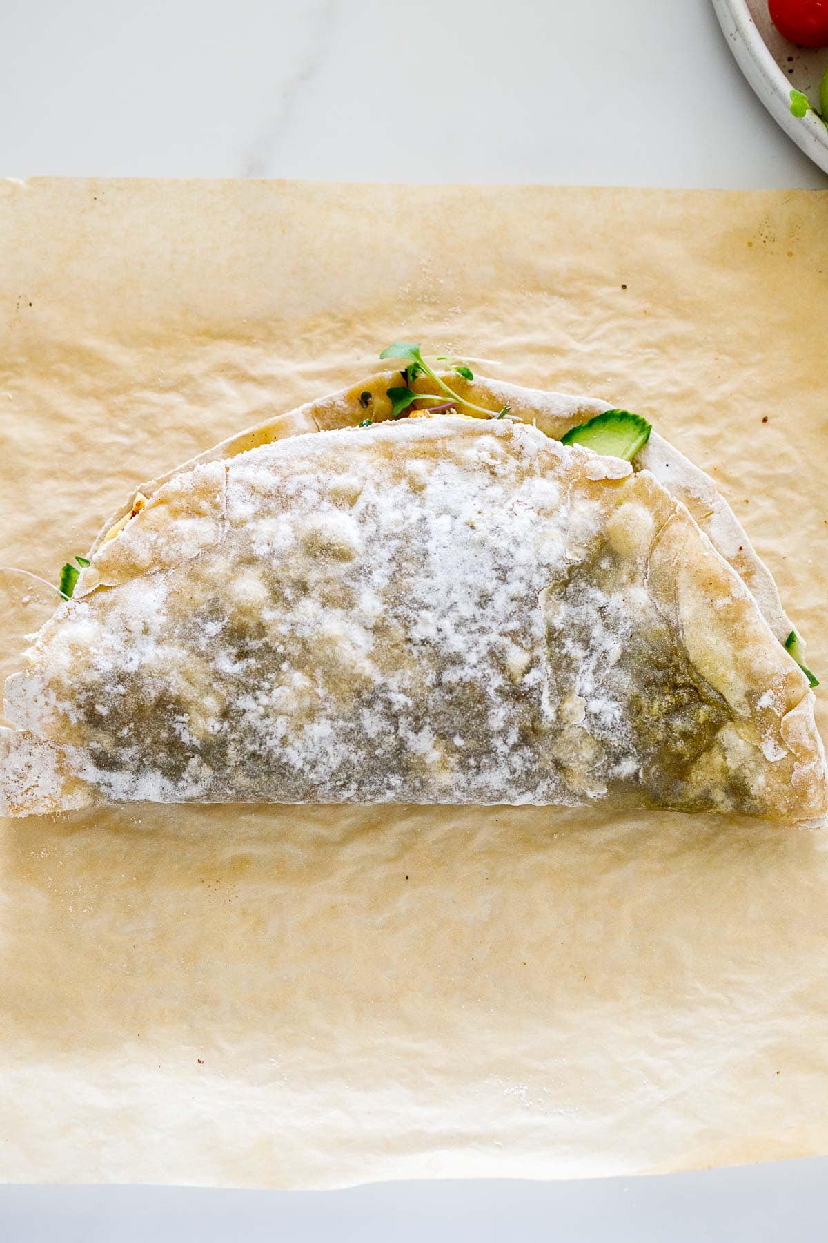 halloumi wrap folded in half on parchment.