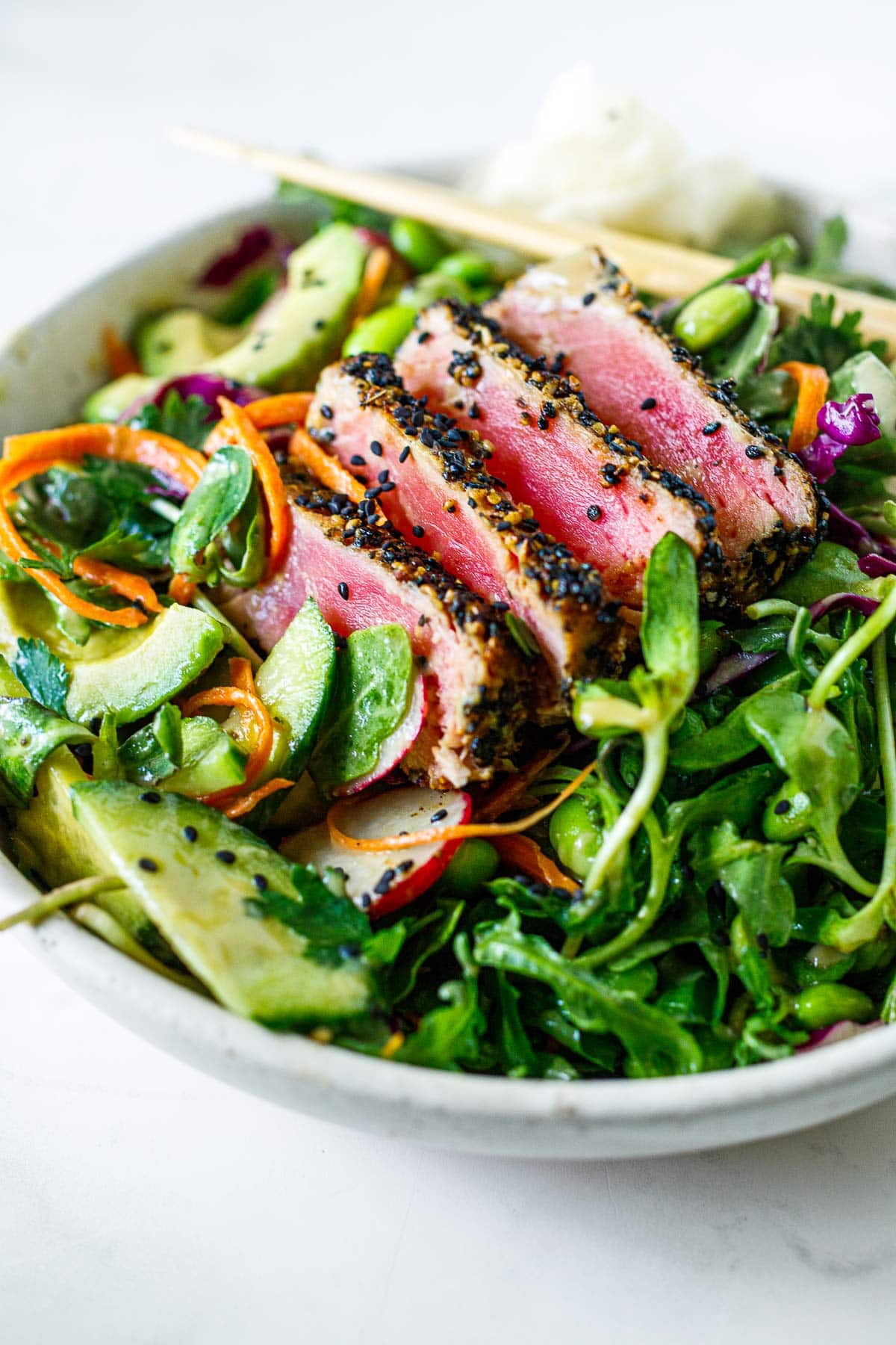 sesame crusted seared ahi tuna salad with sunflower sprouts, sliced cucumber and avocado, grated carrots and cabbage, and edamame. 