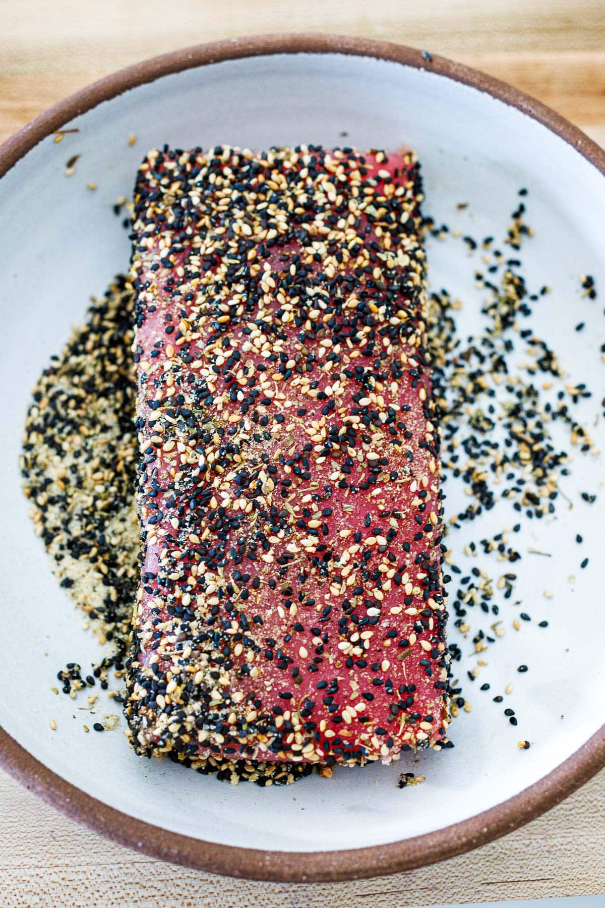 raw ahi tuna with sesame crust on plate. 