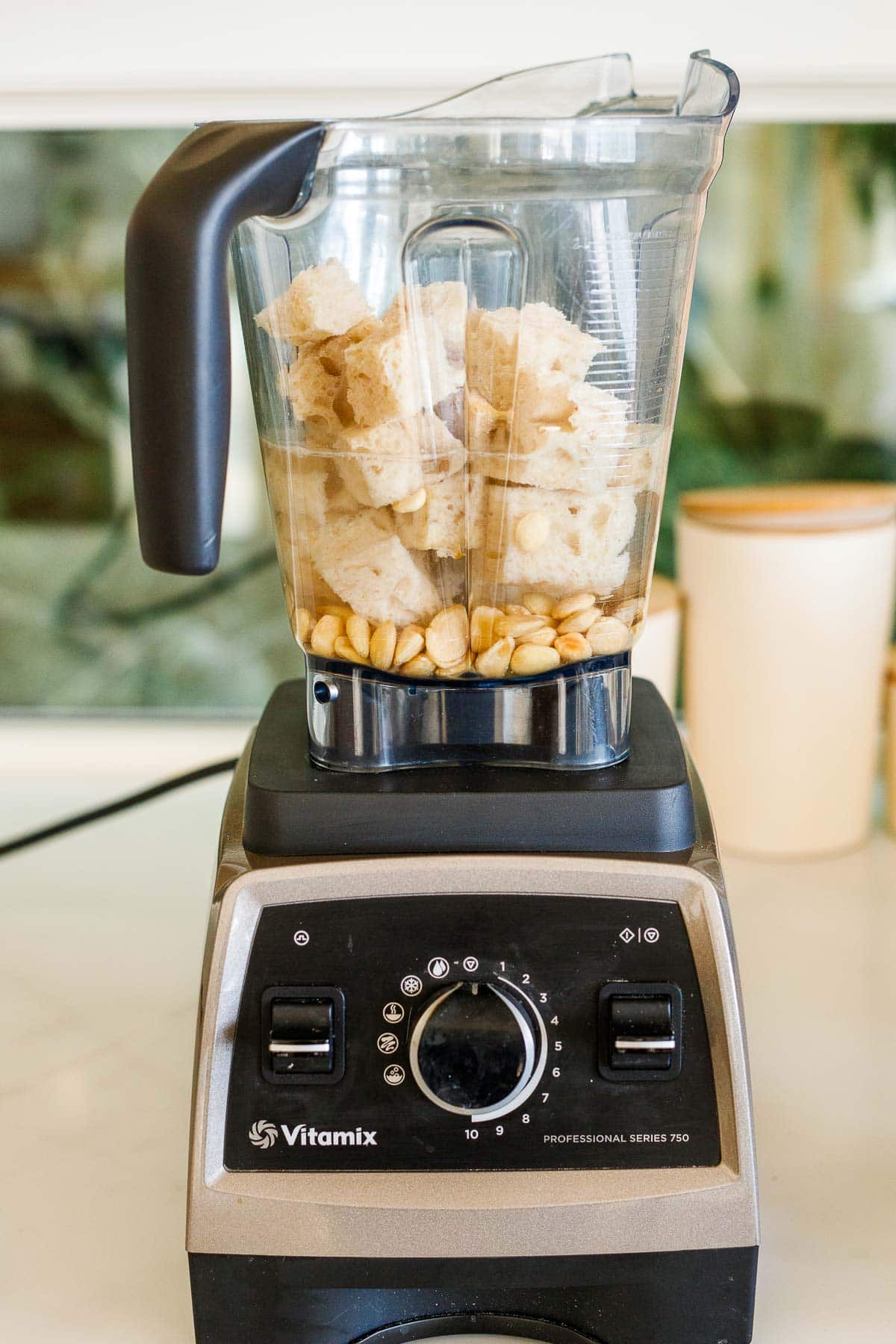 vitamix blender with cubed bread, almonds, and water. 