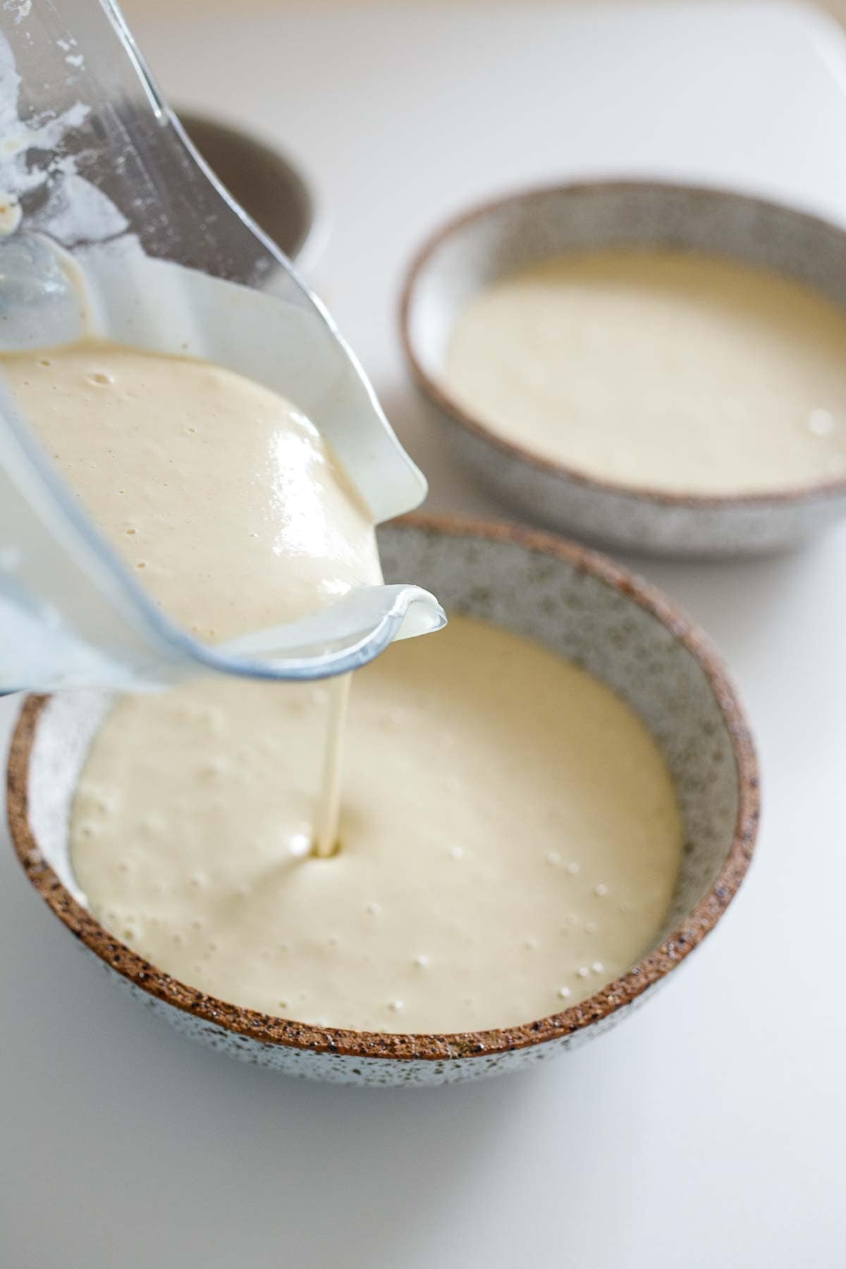 pouring ajo blanco from blender into soup bowls. 