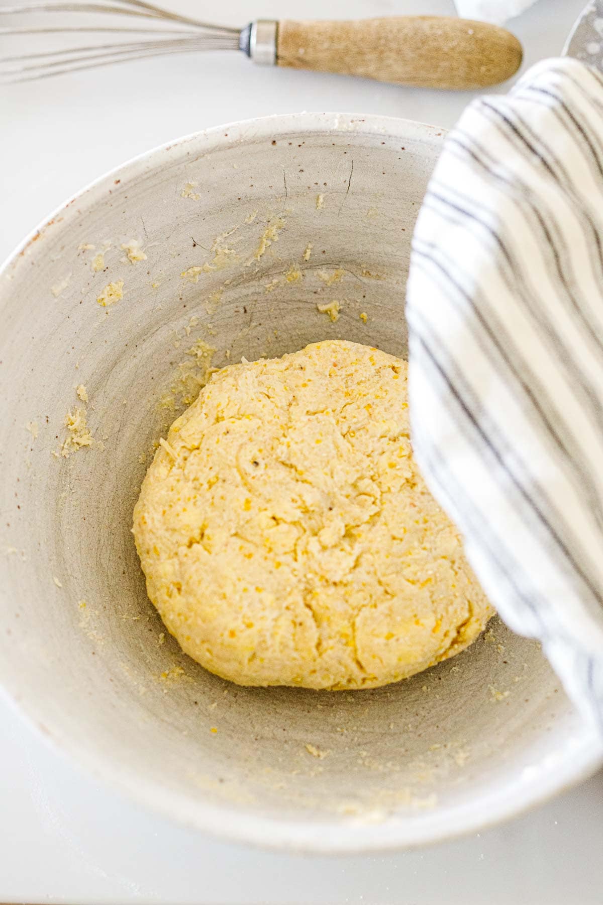 large bowl with galette dough in ball shape with kitchen towel to cover. 