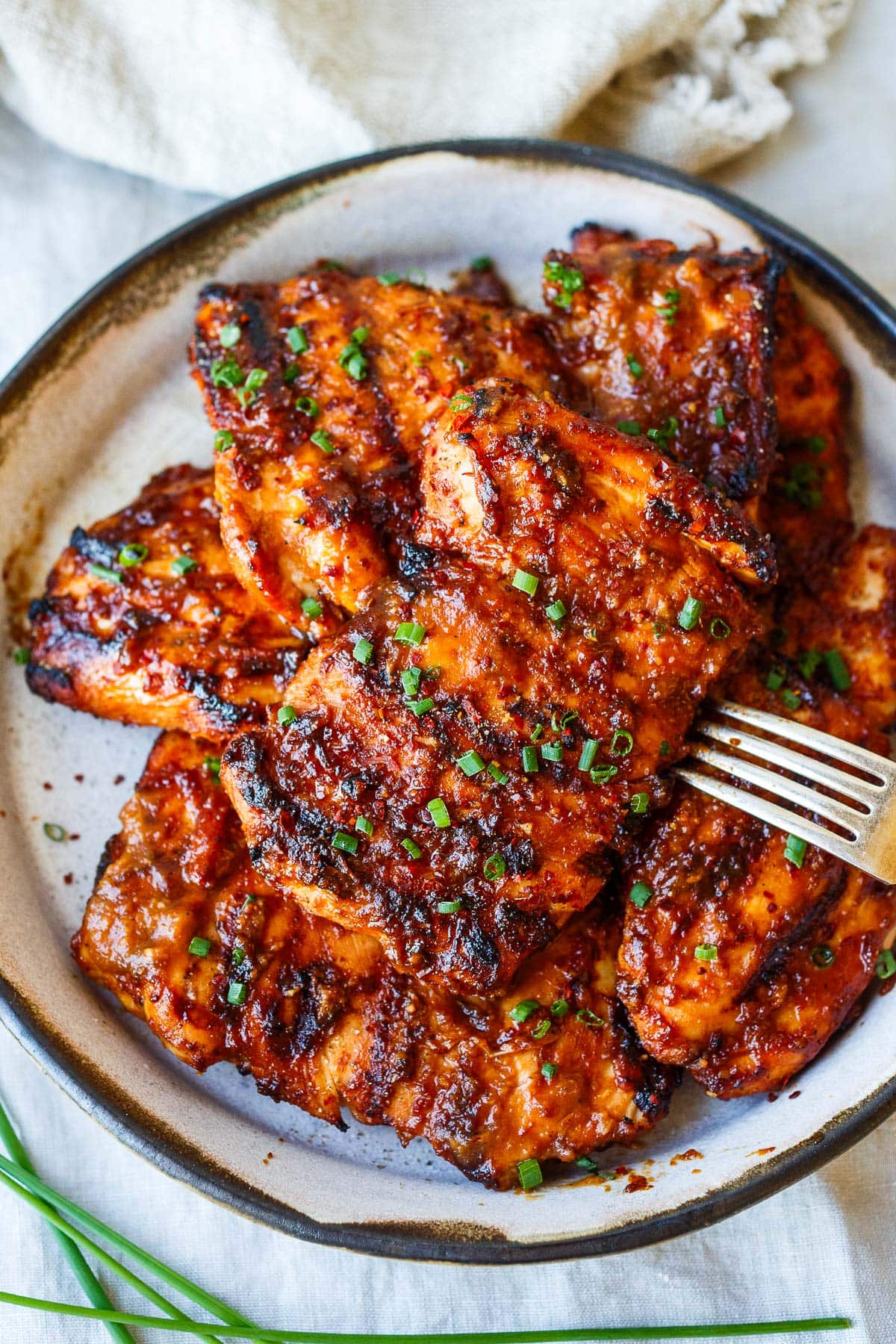 plate of grilled huli huli chicken with chives.