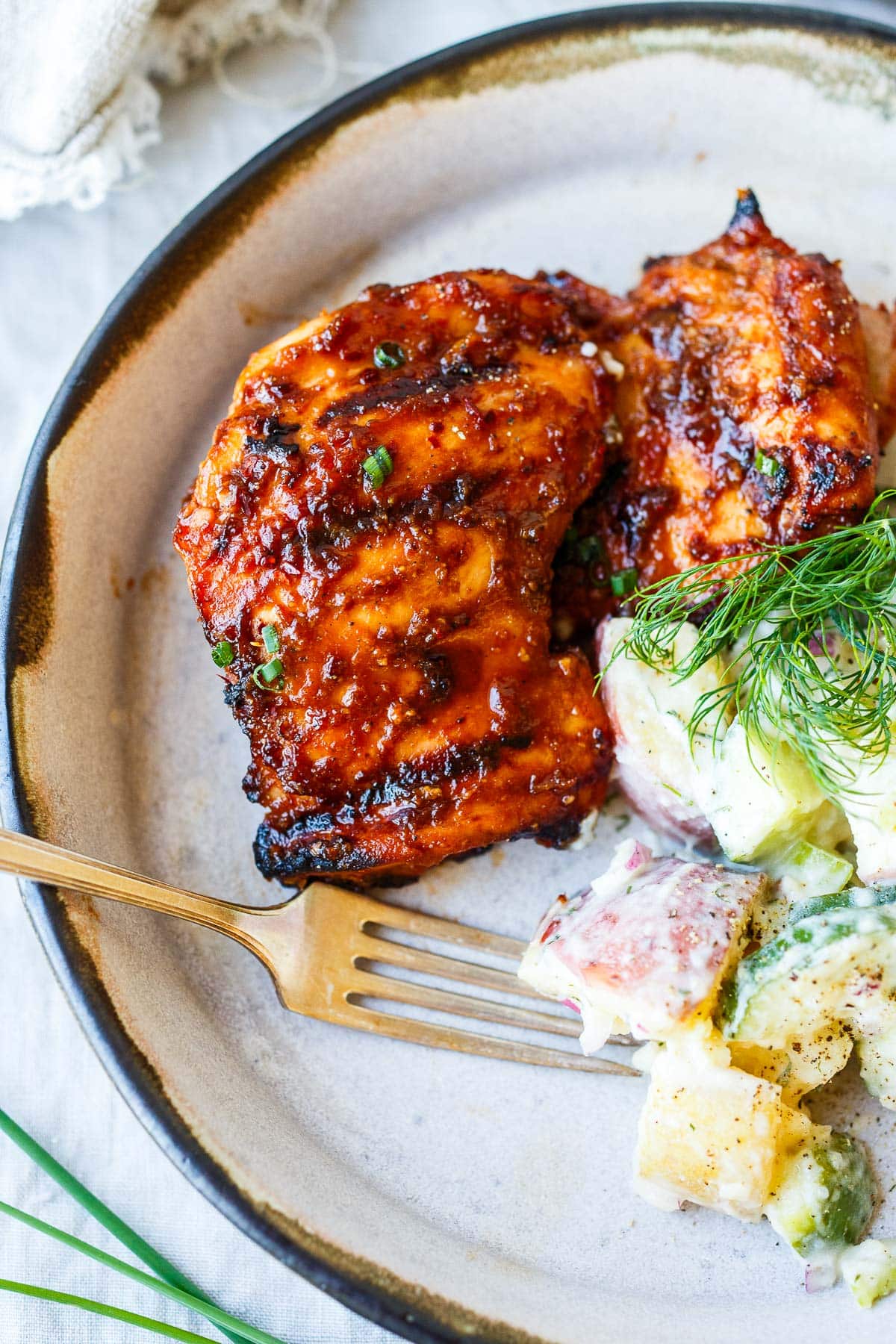 plate of huli huli chicken served with potato salad.