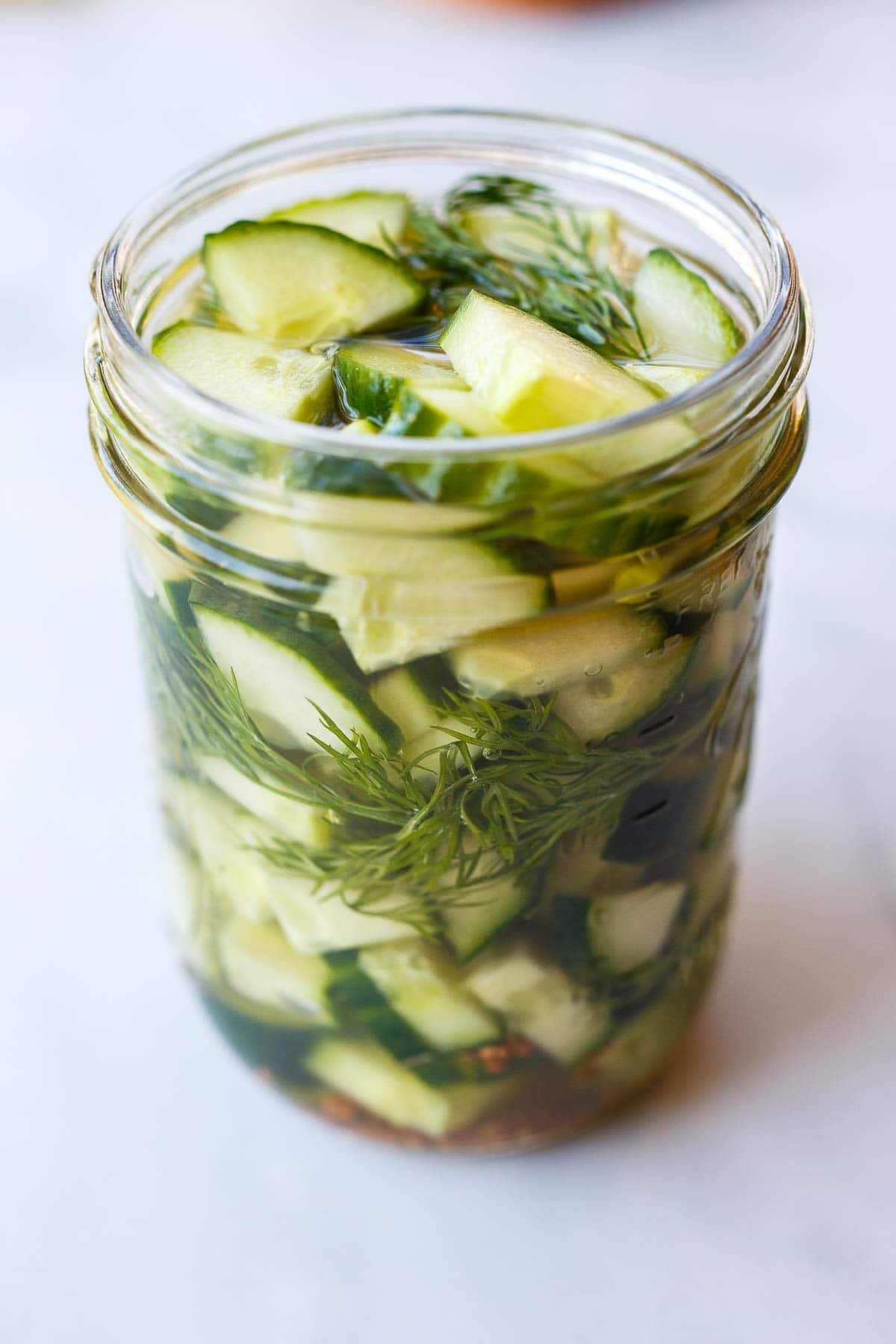 jar with quick pickled cucumbers and dill.