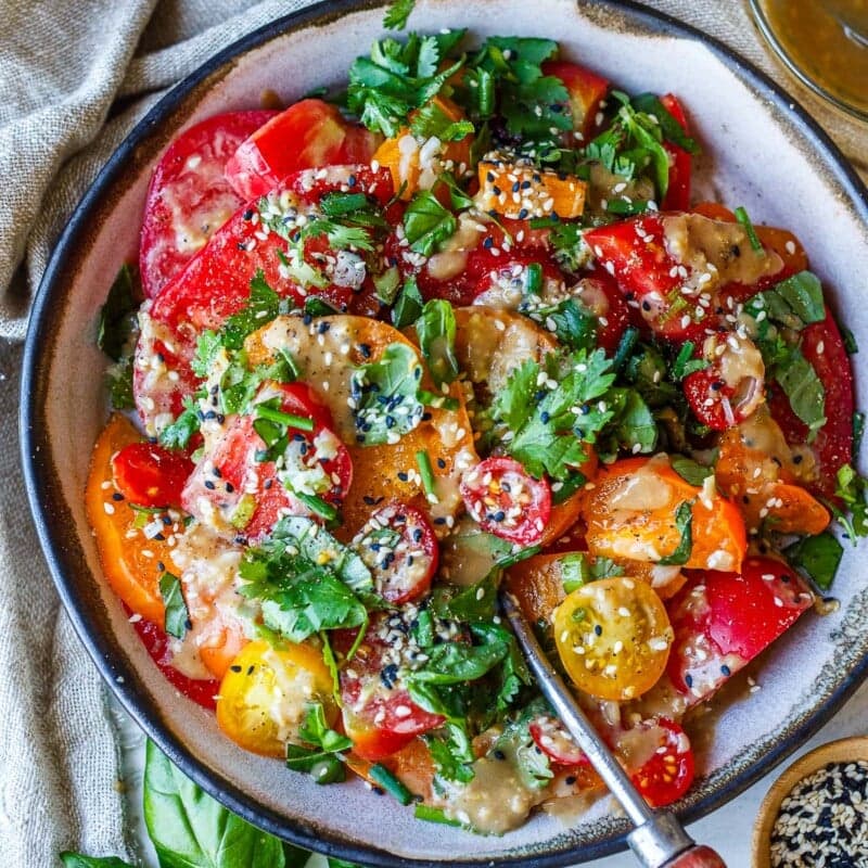 This Sesame Tomato Salad is an easy, delicious way to savor ripe, juicy heirloom tomatoes! It's drizzled with a flavorful sesame ginger dressing, fresh basil, and toasted sesame seeds. Vegan and gluten-free.