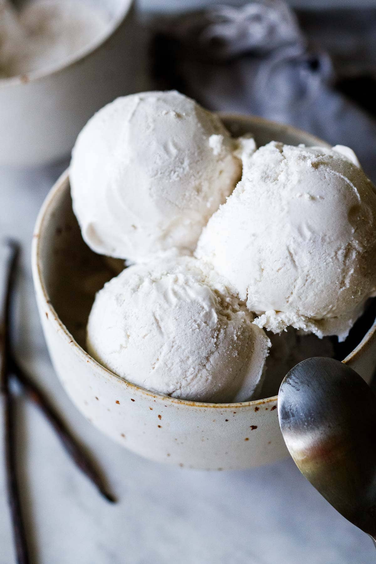 ceramic bowl and spoon with scoops of dairy-free ice cream piled on top.