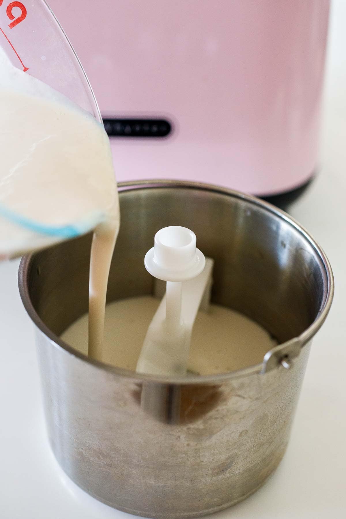pouring ice cream base into base of ice cream maker. 