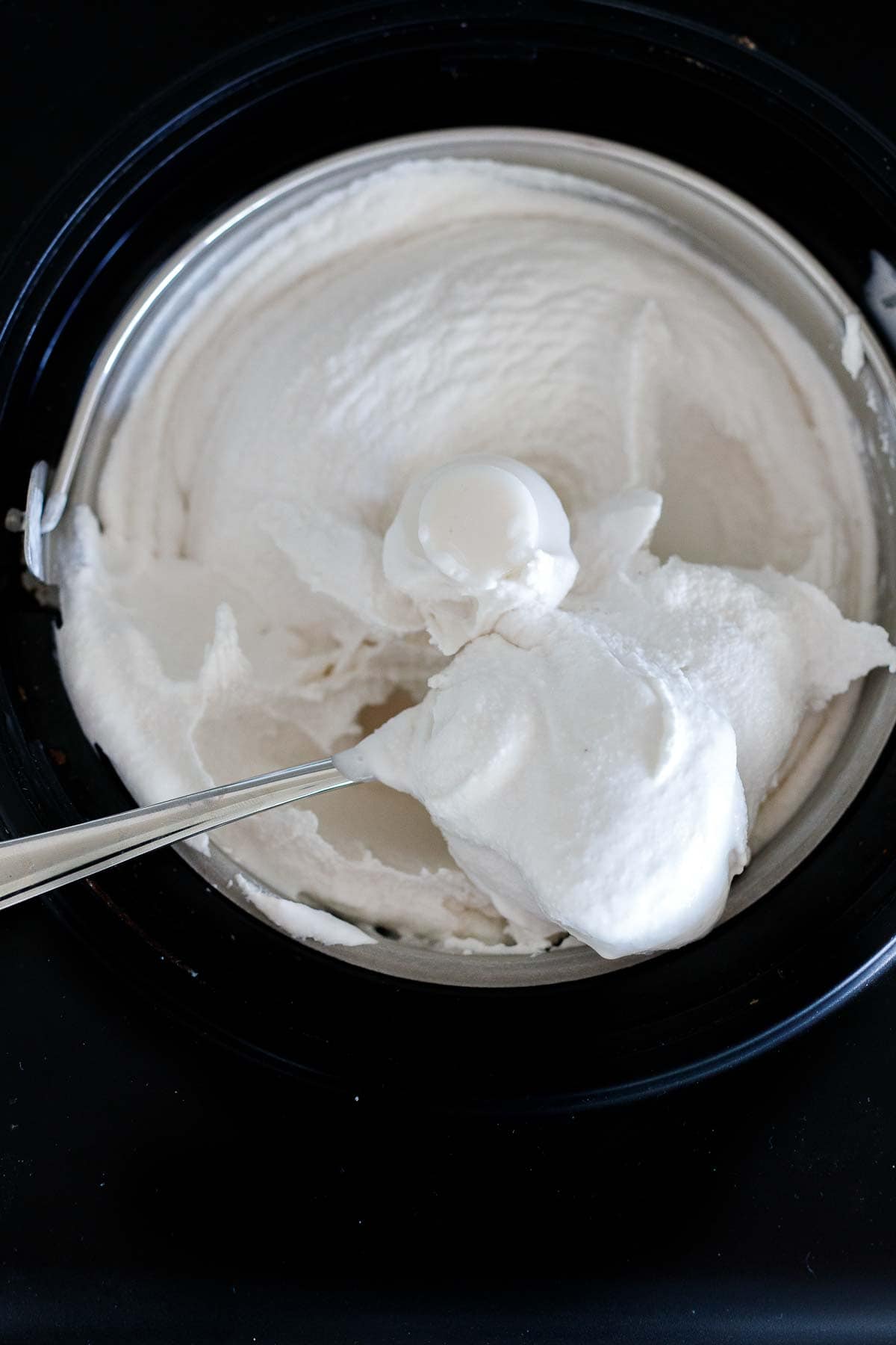 ice cream maker churning dairy-free ice cream- spoonful holding ice cream up.