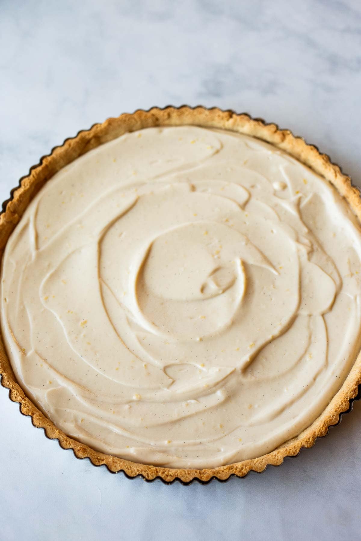 vegan tart with crust and filling spread evenly inside.