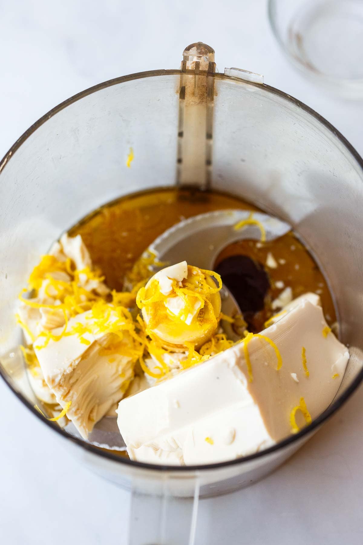 food processor with silken tofu, lemon zest, and other ingredients to make vegan tart filling.