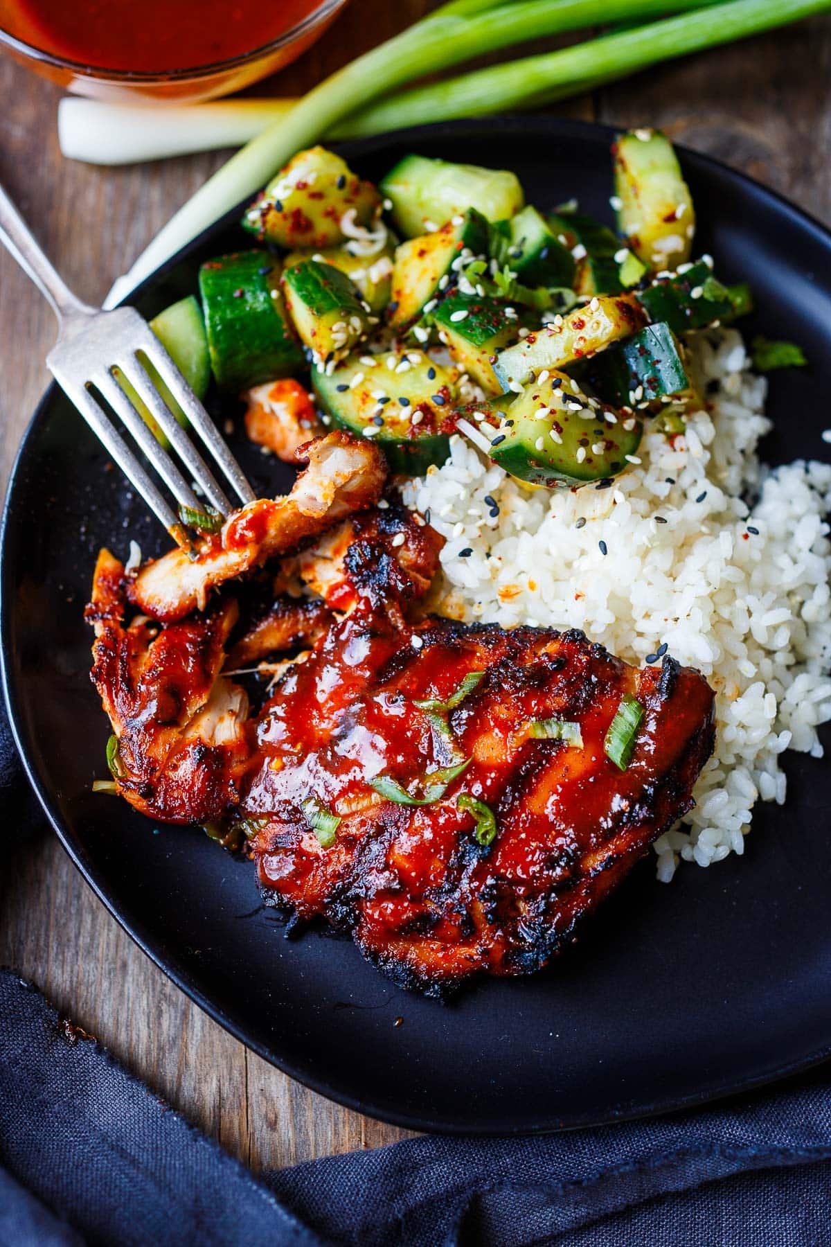plate with Korean bbq chicken, rice, and Korean cucumber salad. 
