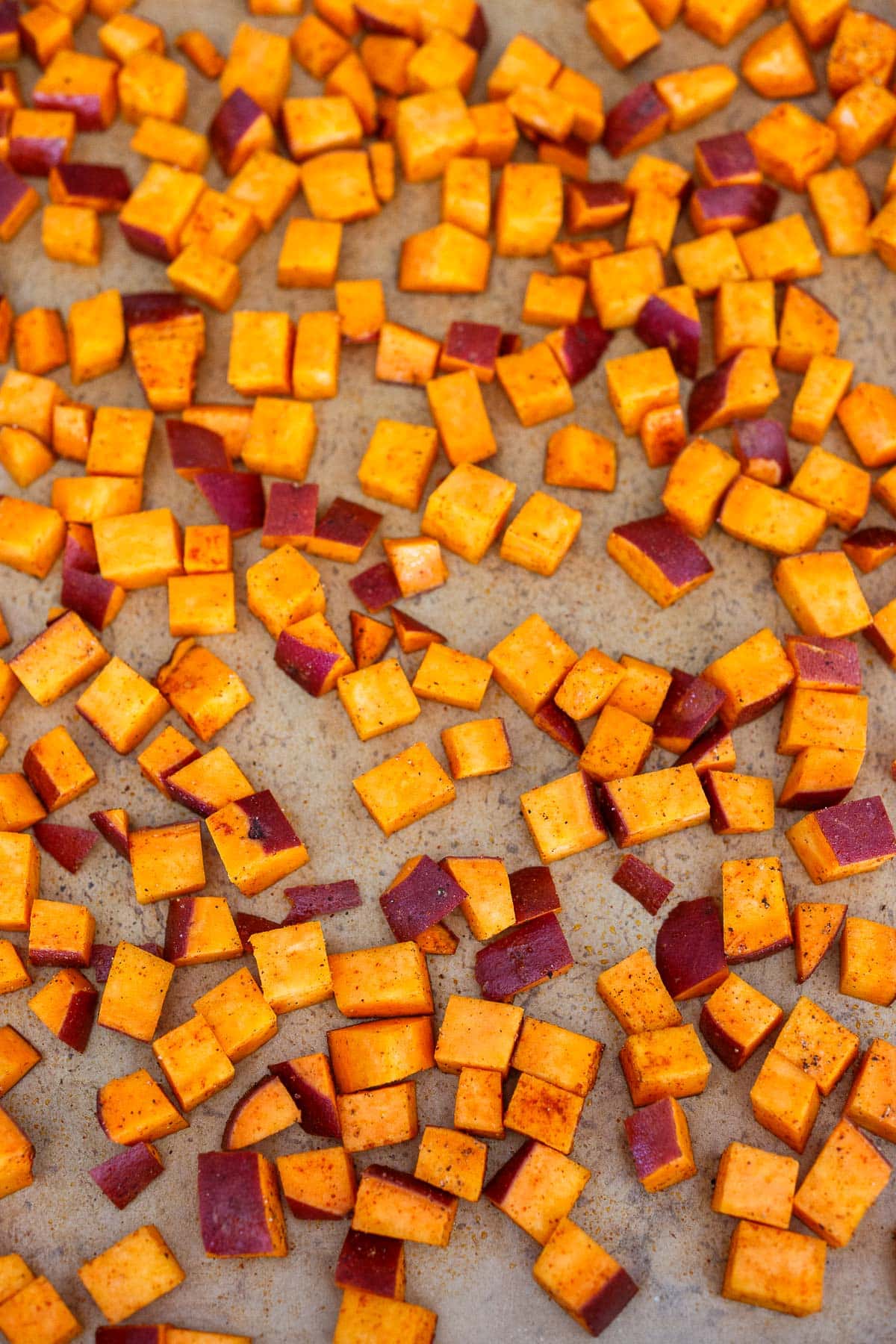baking sheet with diced sweet potatoes seasoned with smoked paprika, salt, and pepper. 