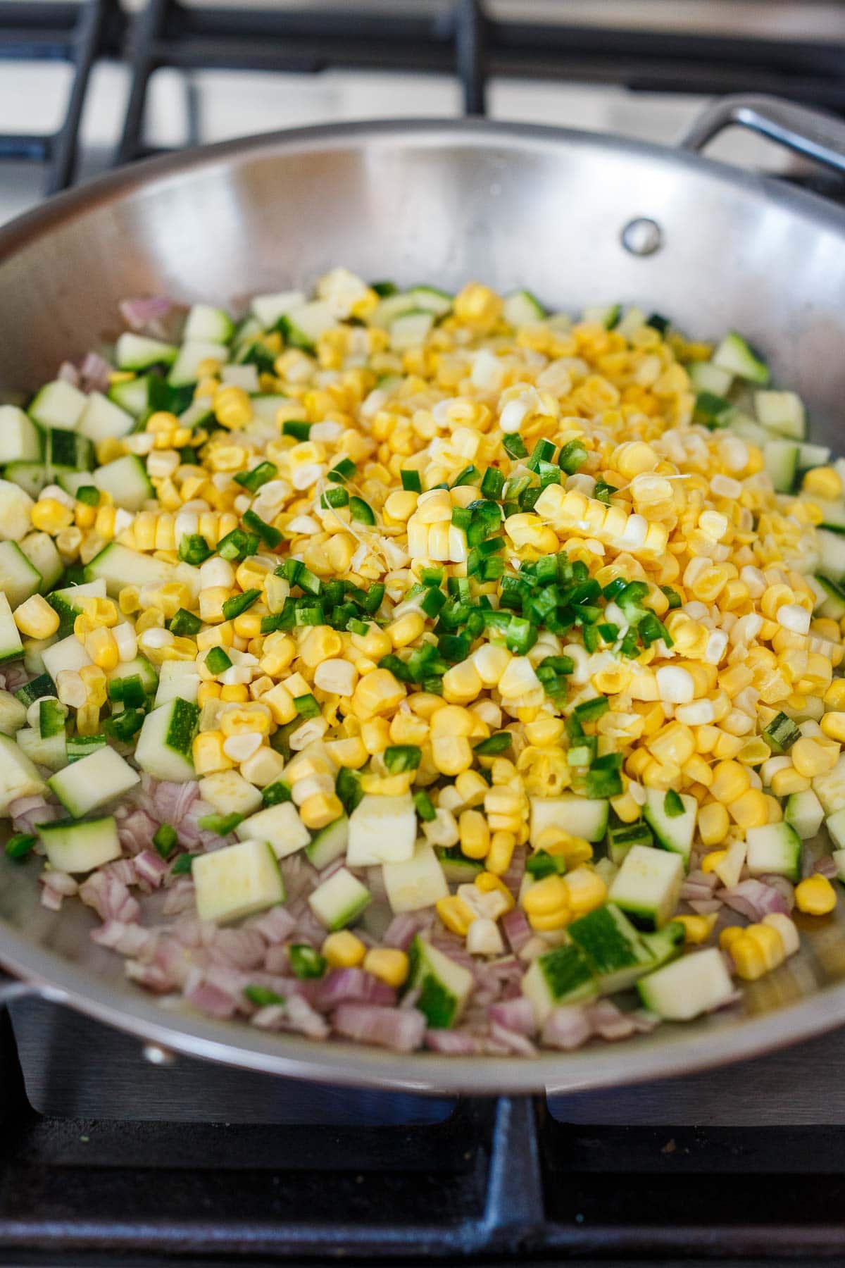 skillet with corn, jalapeño, zucchini, and shallot. 