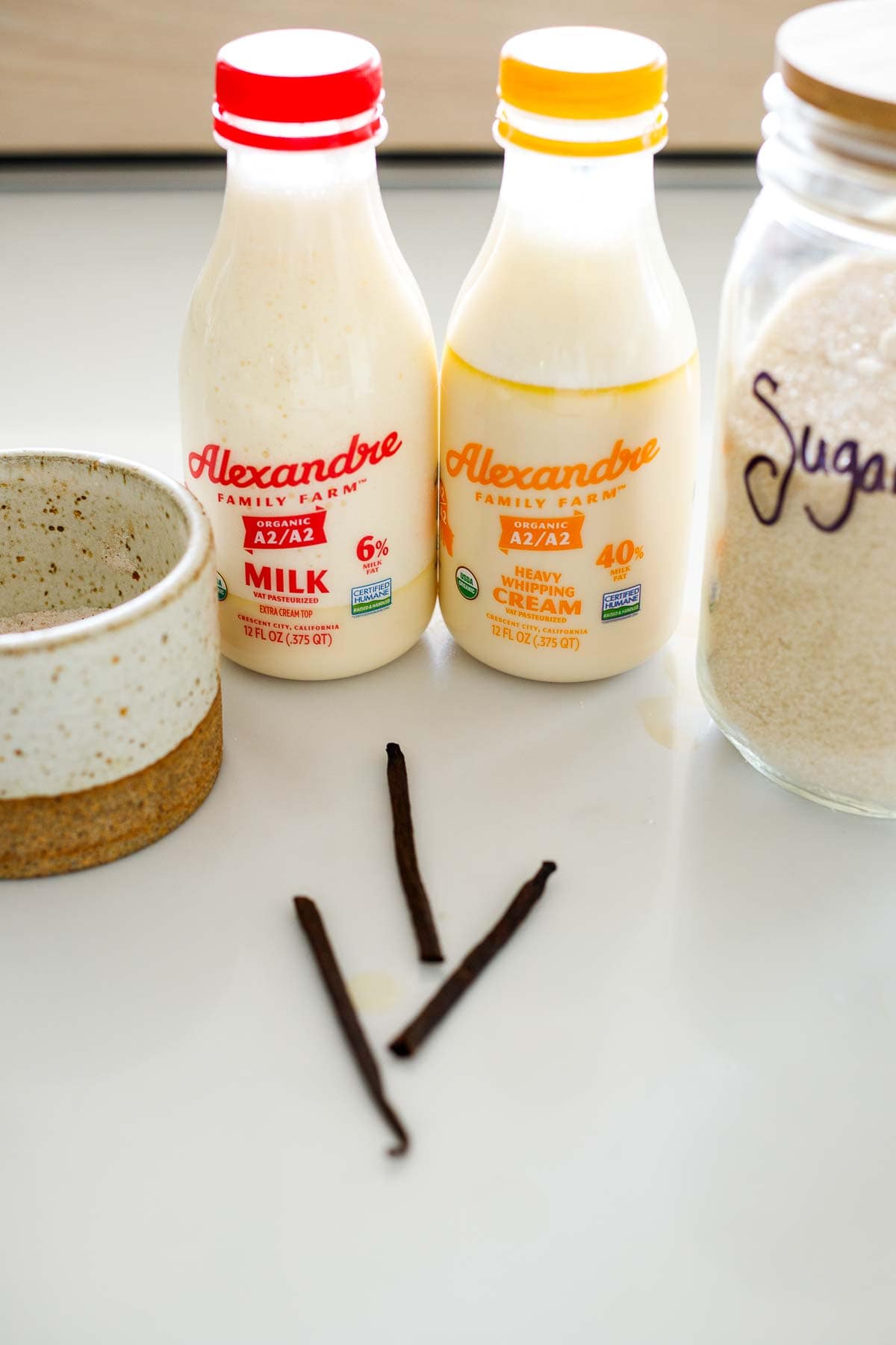 ingredients for homemade ice cream - milk, heavy cream, sugar, salt, vanilla beans.