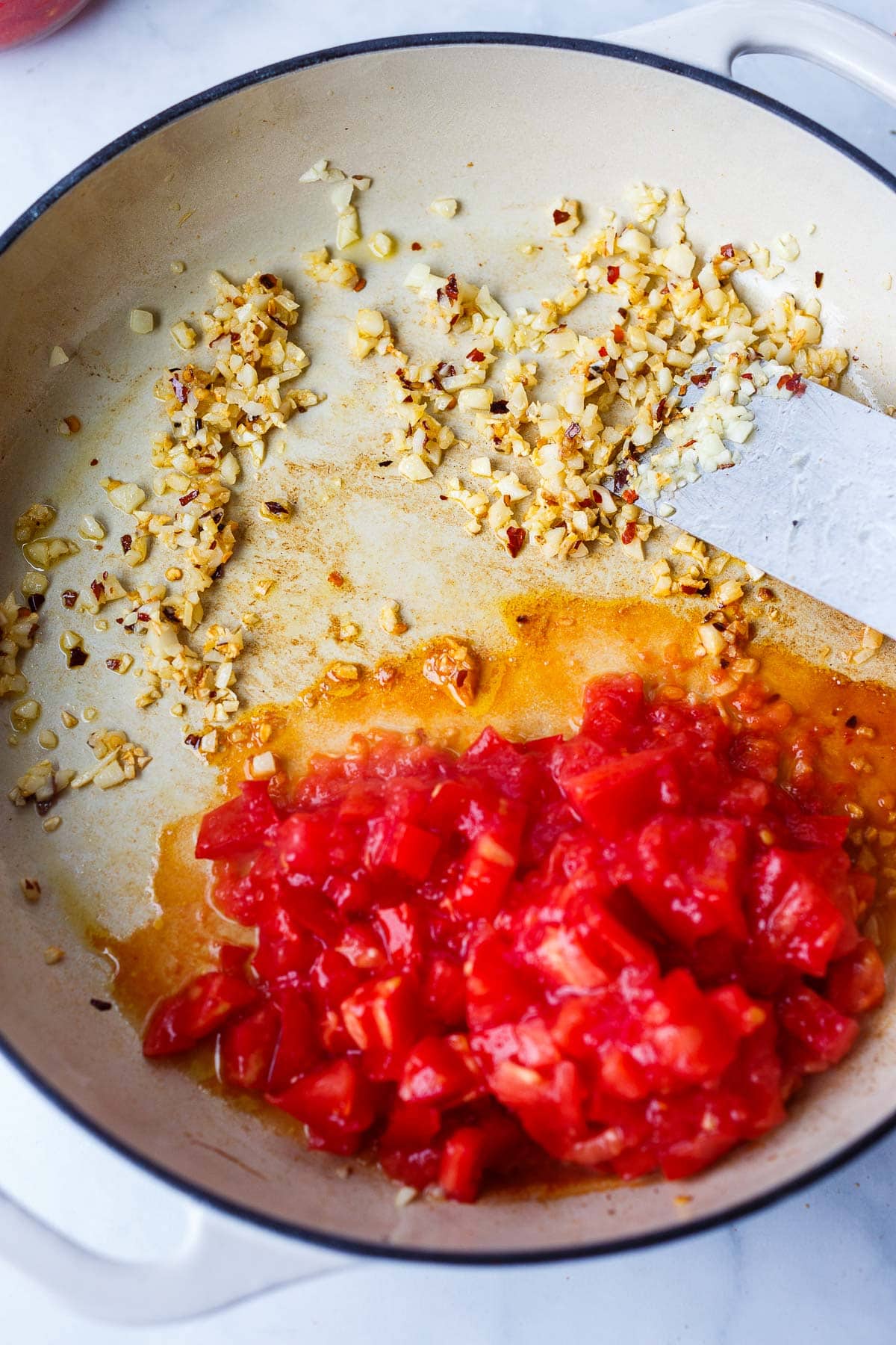 pan with garlic, chili flakes and tomatoes. 