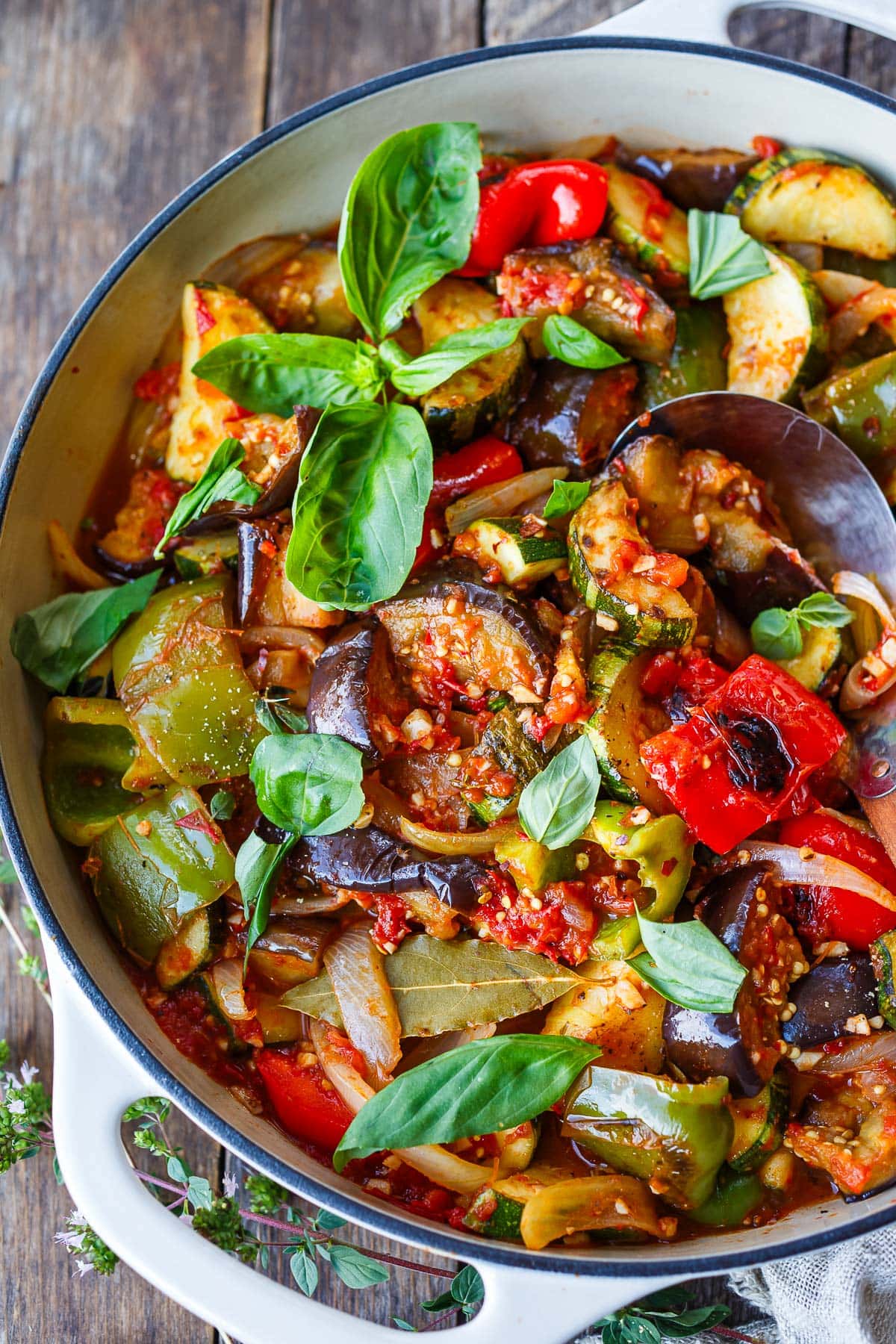 pot of ratatouille with stewed vegetables and fresh basil.