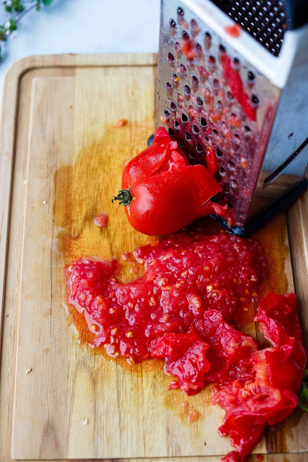 grating tomato on cutting board. 