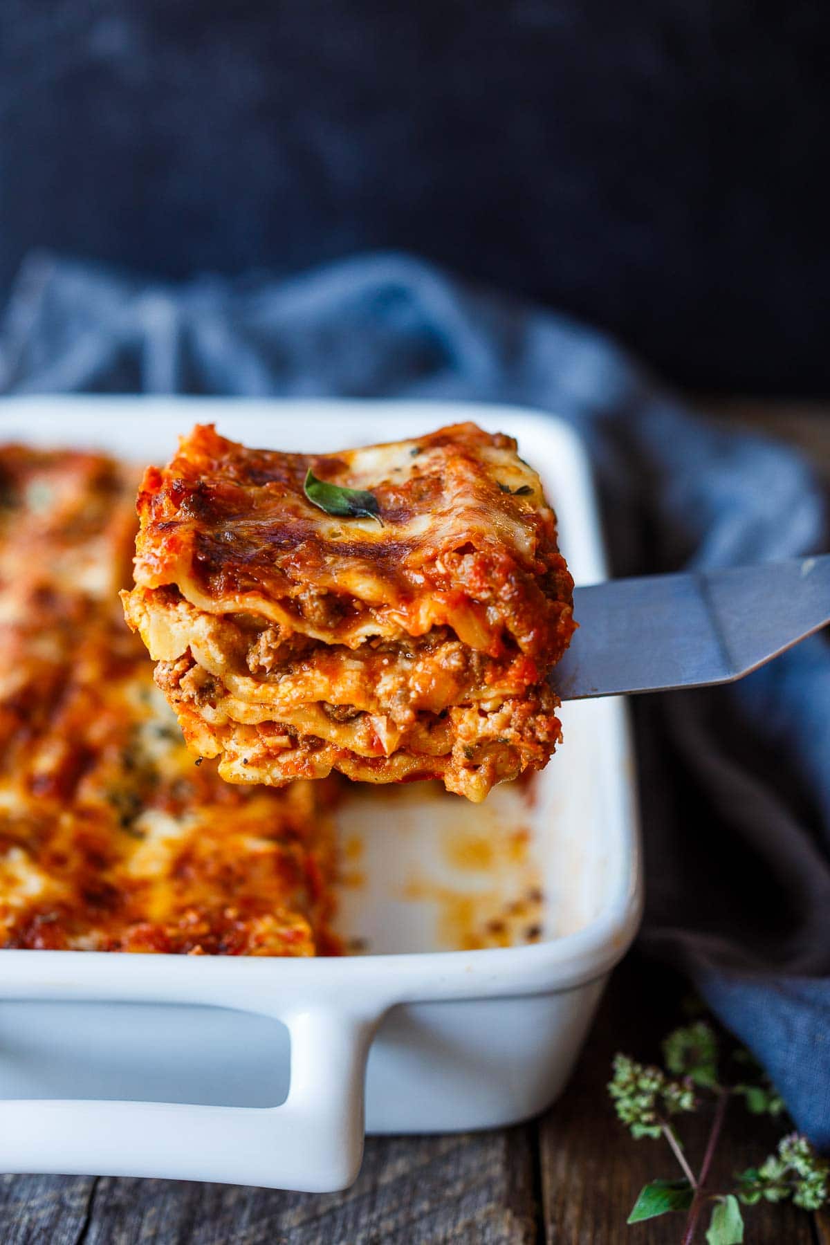 spatula lifting slice of lasagna from the baking dish.