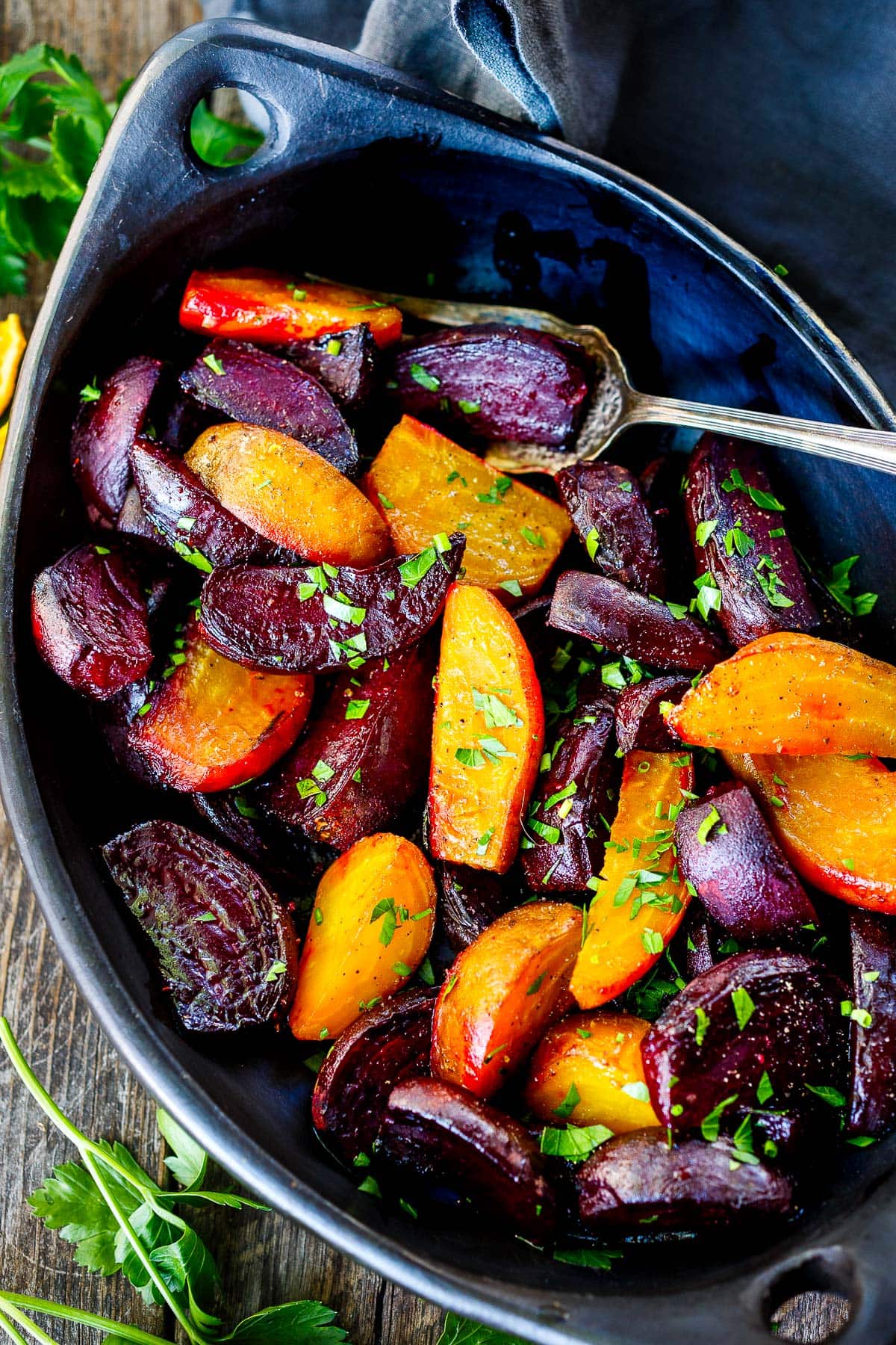 serving dish with roasted beets and fresh herbs with serving spoon.