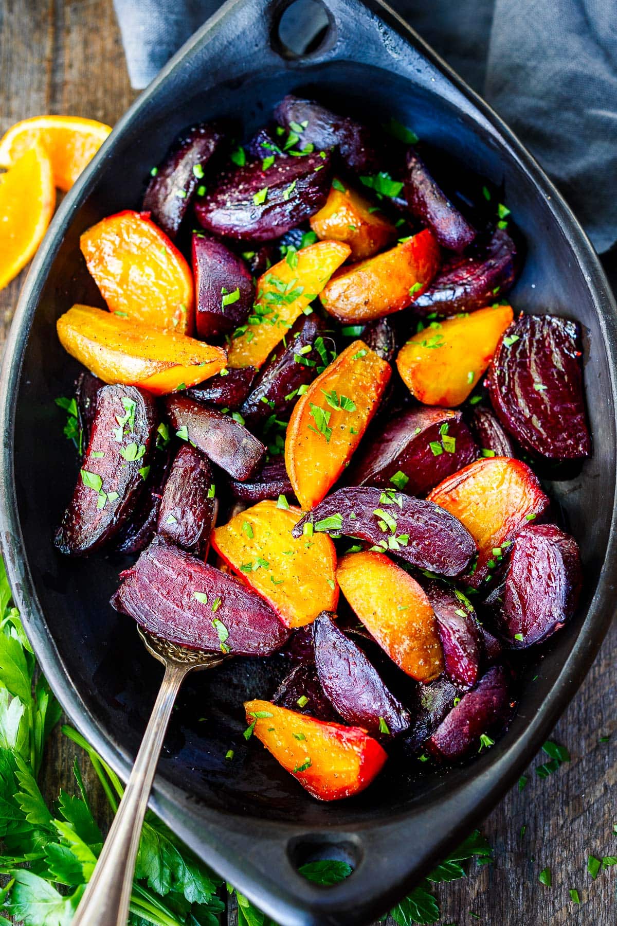 serving dish with roasted beets seasoned in pepper and garnished with fresh herbs.