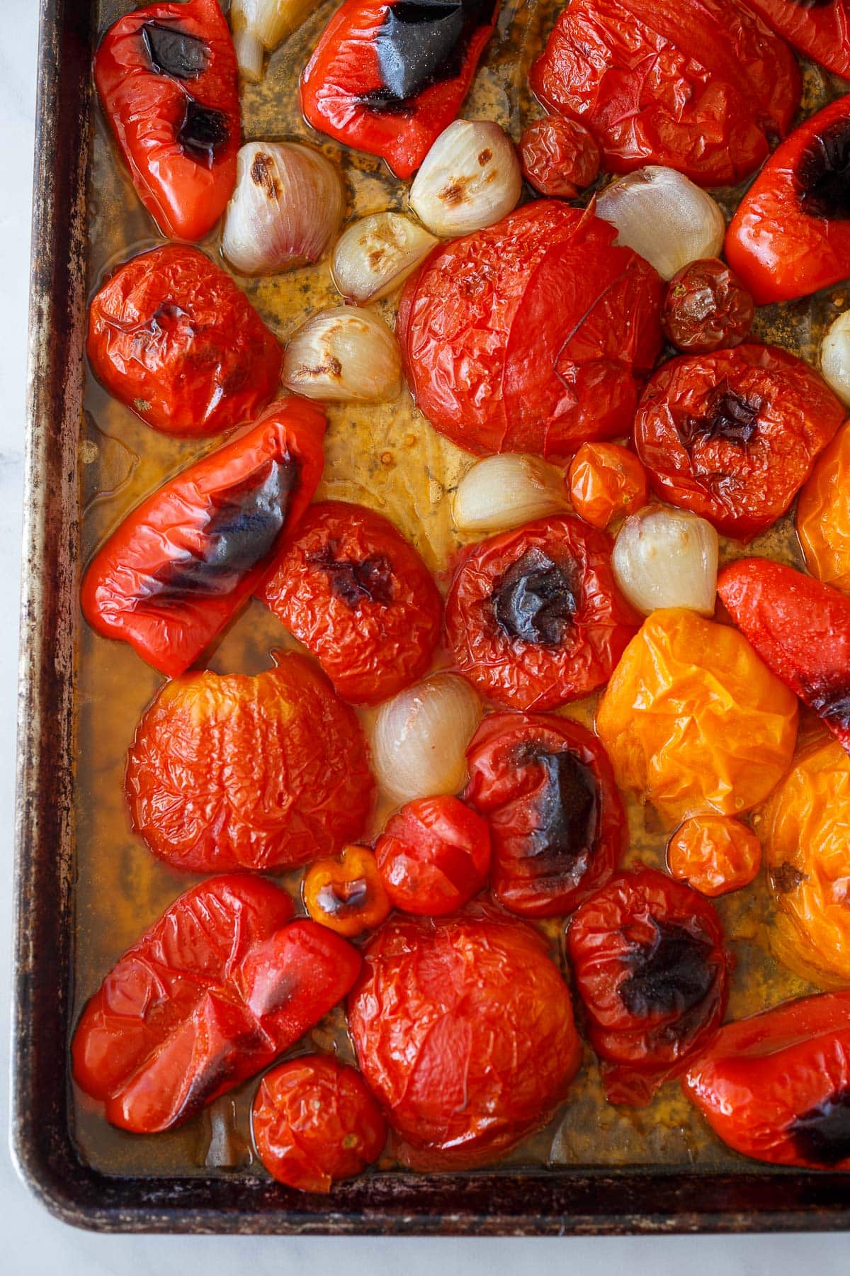 roasted red bell peppers, tomatoes, and shallots on parchment-lined baking sheet. 