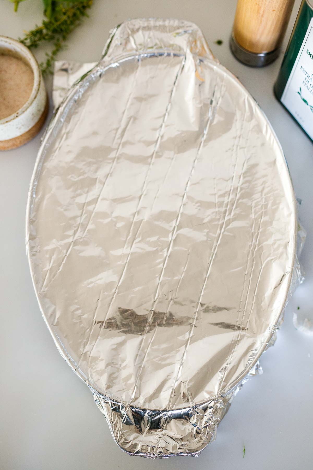 foil wrapped around oval baking dish. 