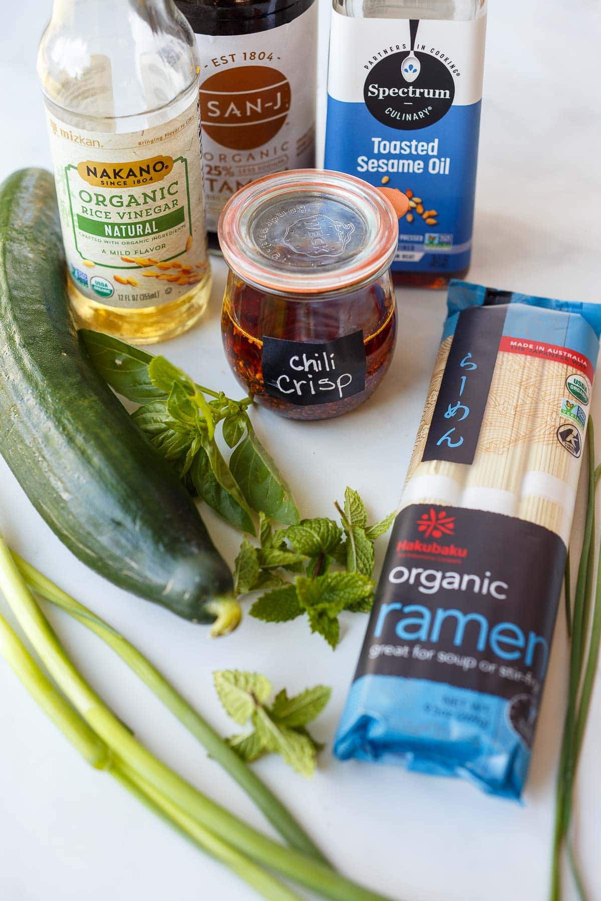 ingredients for cucumber noodle salad - toasted sesame oil, tamari, rice vinegar, cucumber, fresh herbs, ramen noodles.