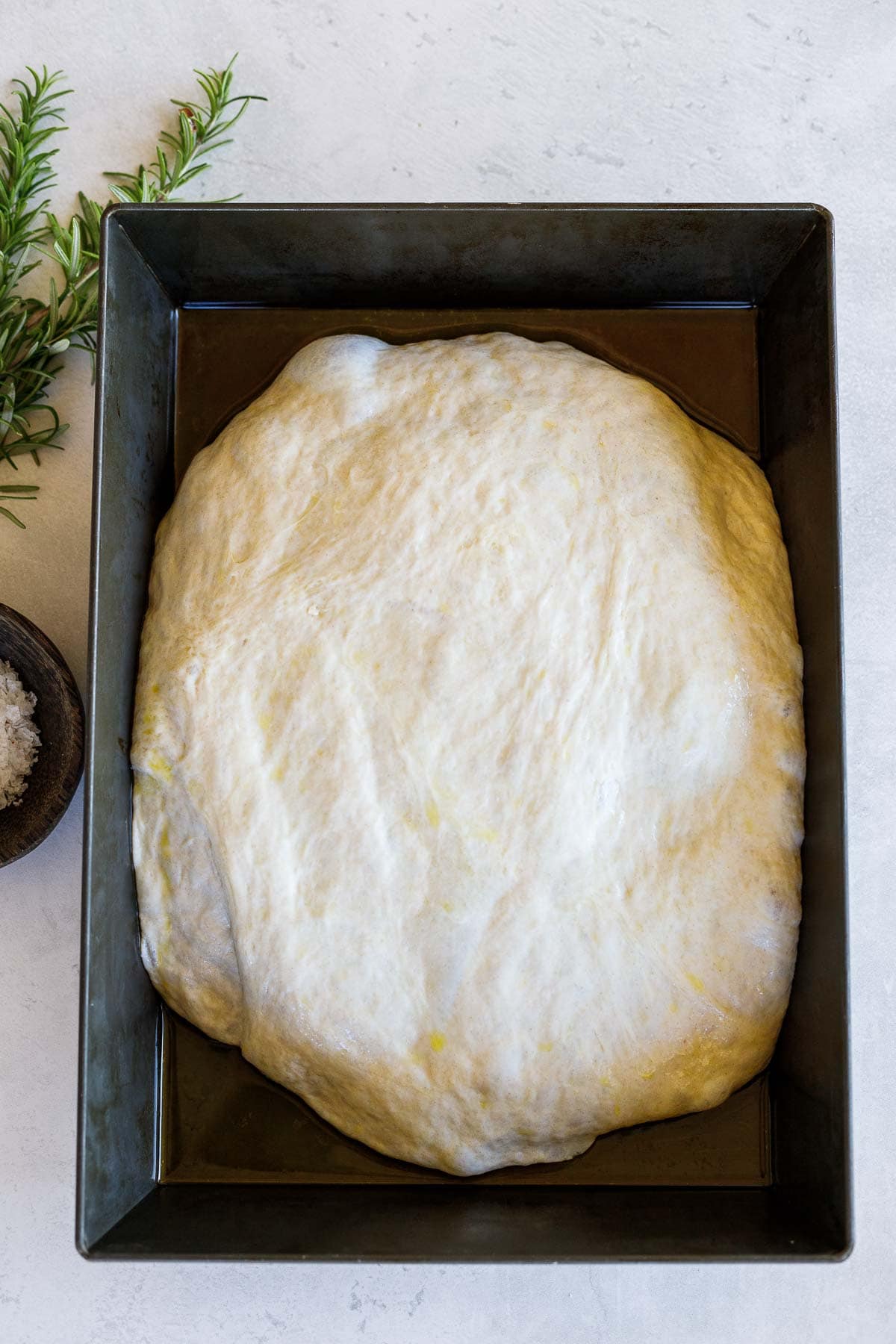 focaccia dough risen on baking sheet.
