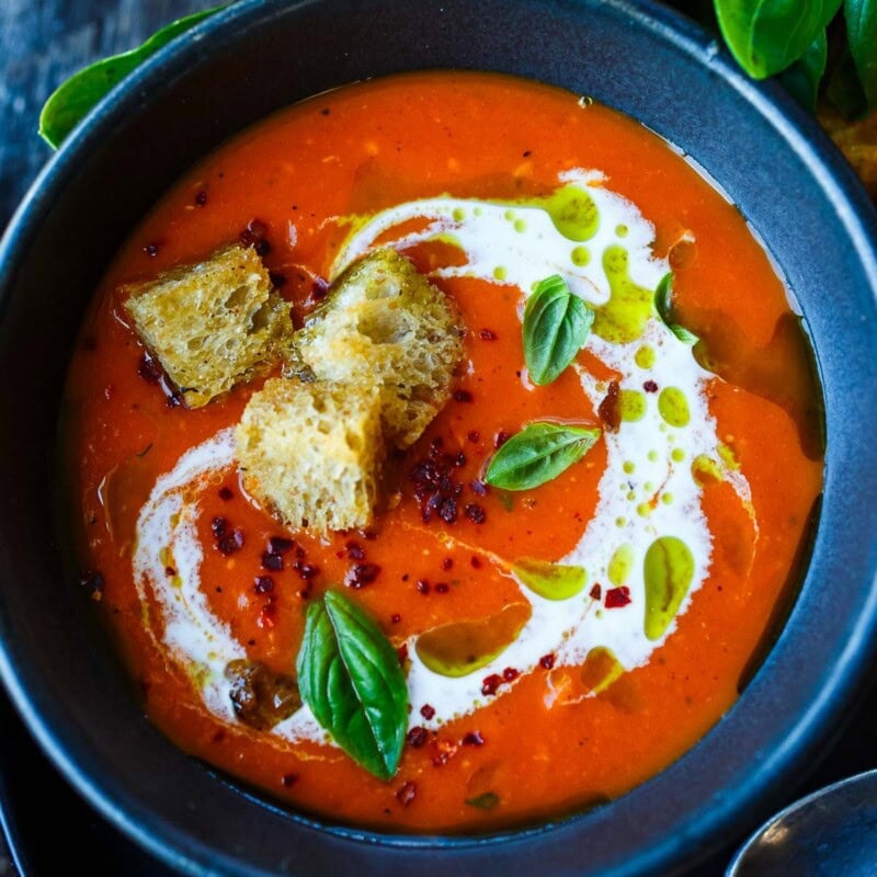 Roasted Red Pepper and Tomato Soup is a twist on classic tomato soup, with the delicious sweetness and smoky flavor of roasted red peppers and tomatoes. Top with croutons and fresh basil. Vegan.