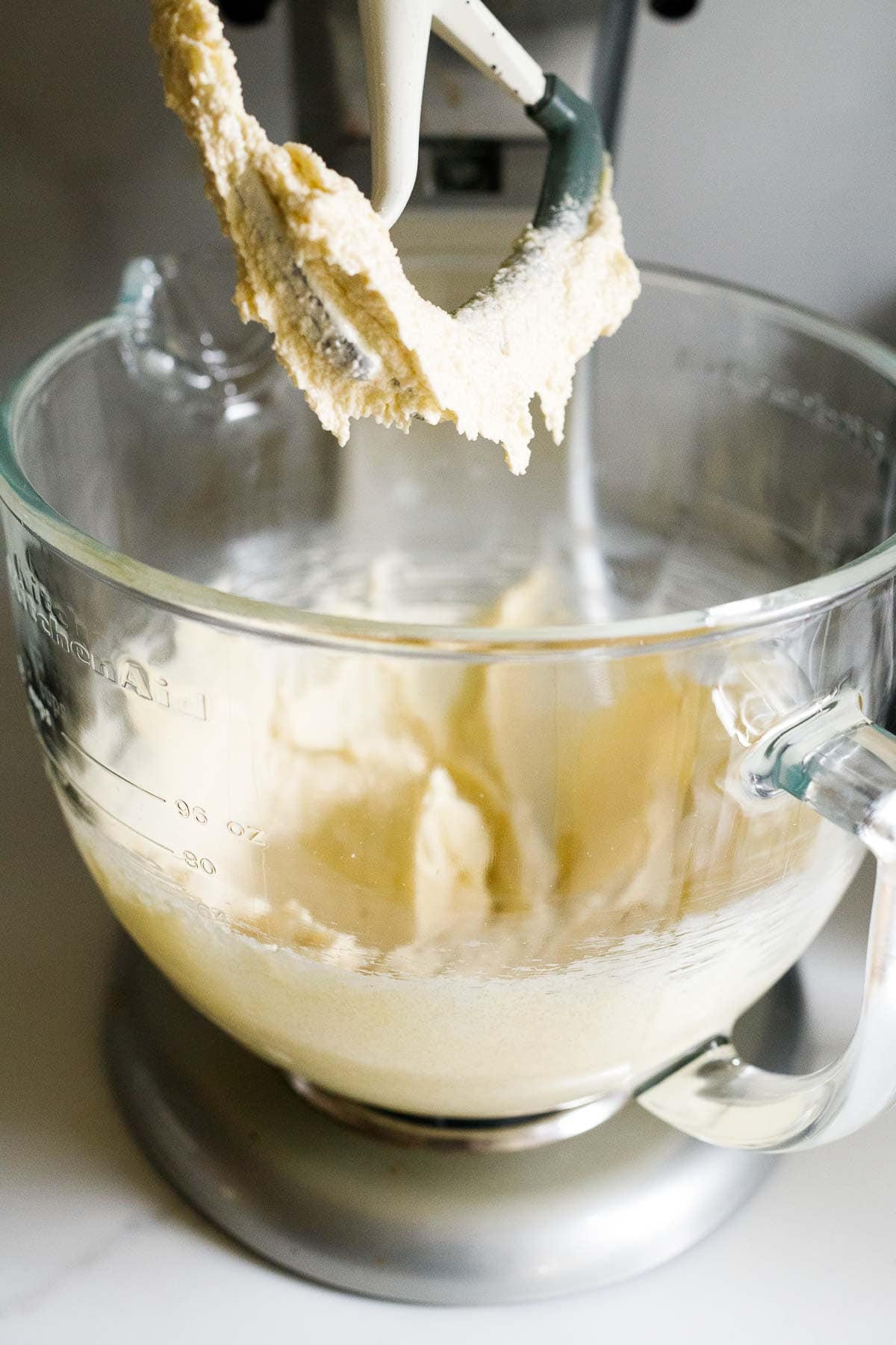 stand mixer with paddle attachment whipping up butter, olive oil, and eggs. 